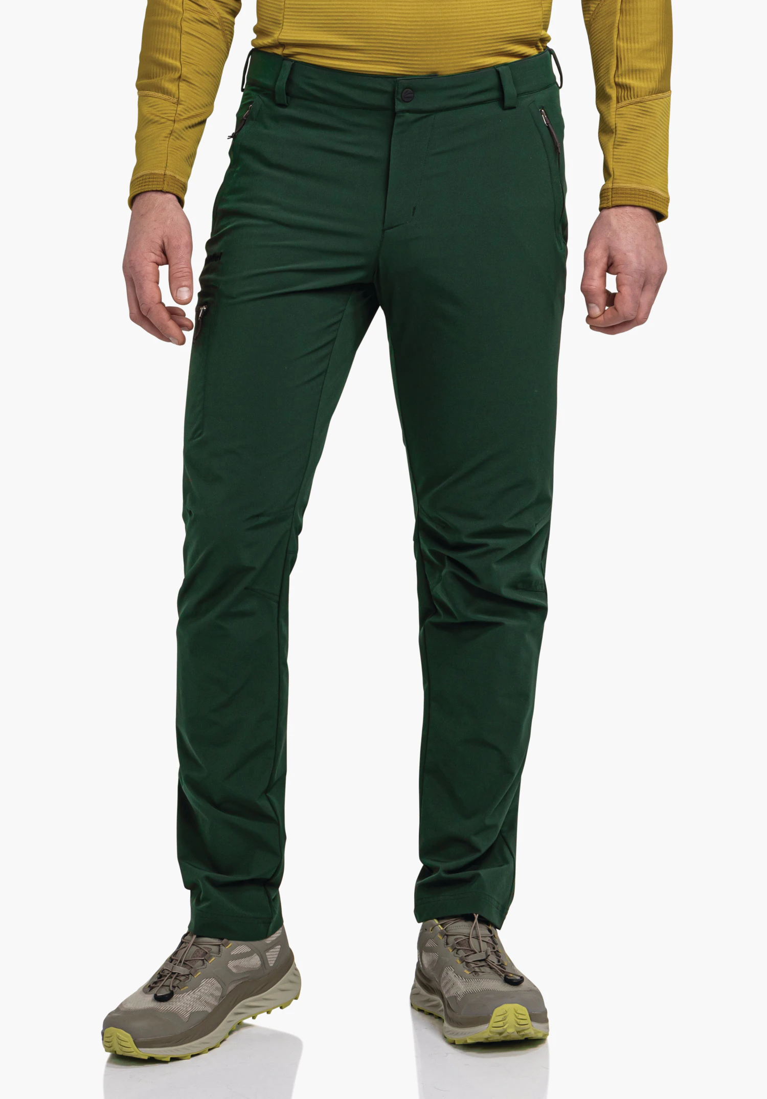 Pants Folkstone donkergroene broek gedragen door een staande persoon; benen licht uit elkaar, gecombineerd met een donkergeel shirt met lange mouwen; effen achtergrond.