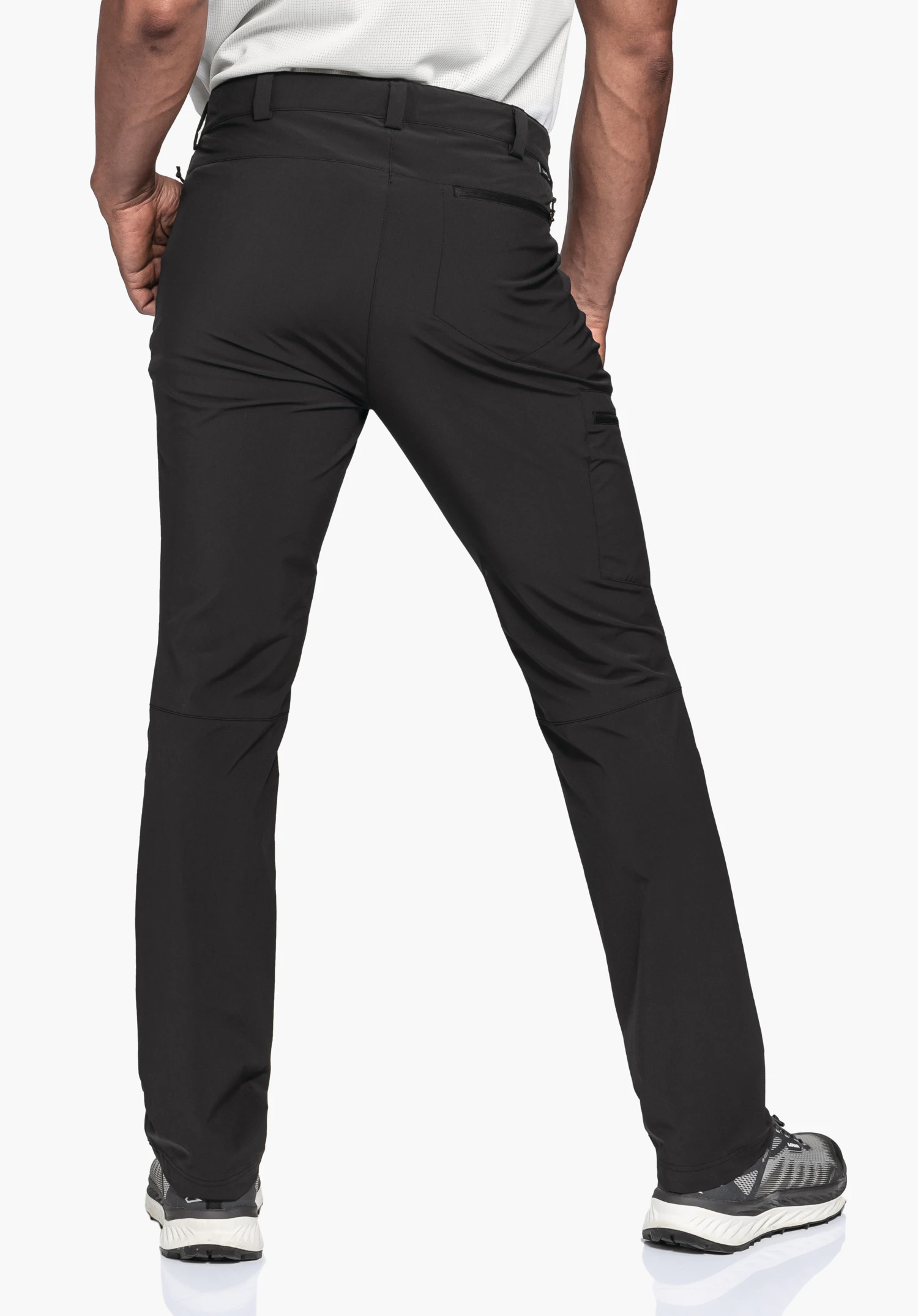 Pants Folkstone in schwarz an einem Model in der Rückenansicht. Die Hose verfügt über Gürtelschlaufen, eine seitliche Beintasche sowie eine Gesäßtasche mit Reißverschluss. Das Model steht mit leicht geöffneten Beinen vor einem neutralen Hintergrund.