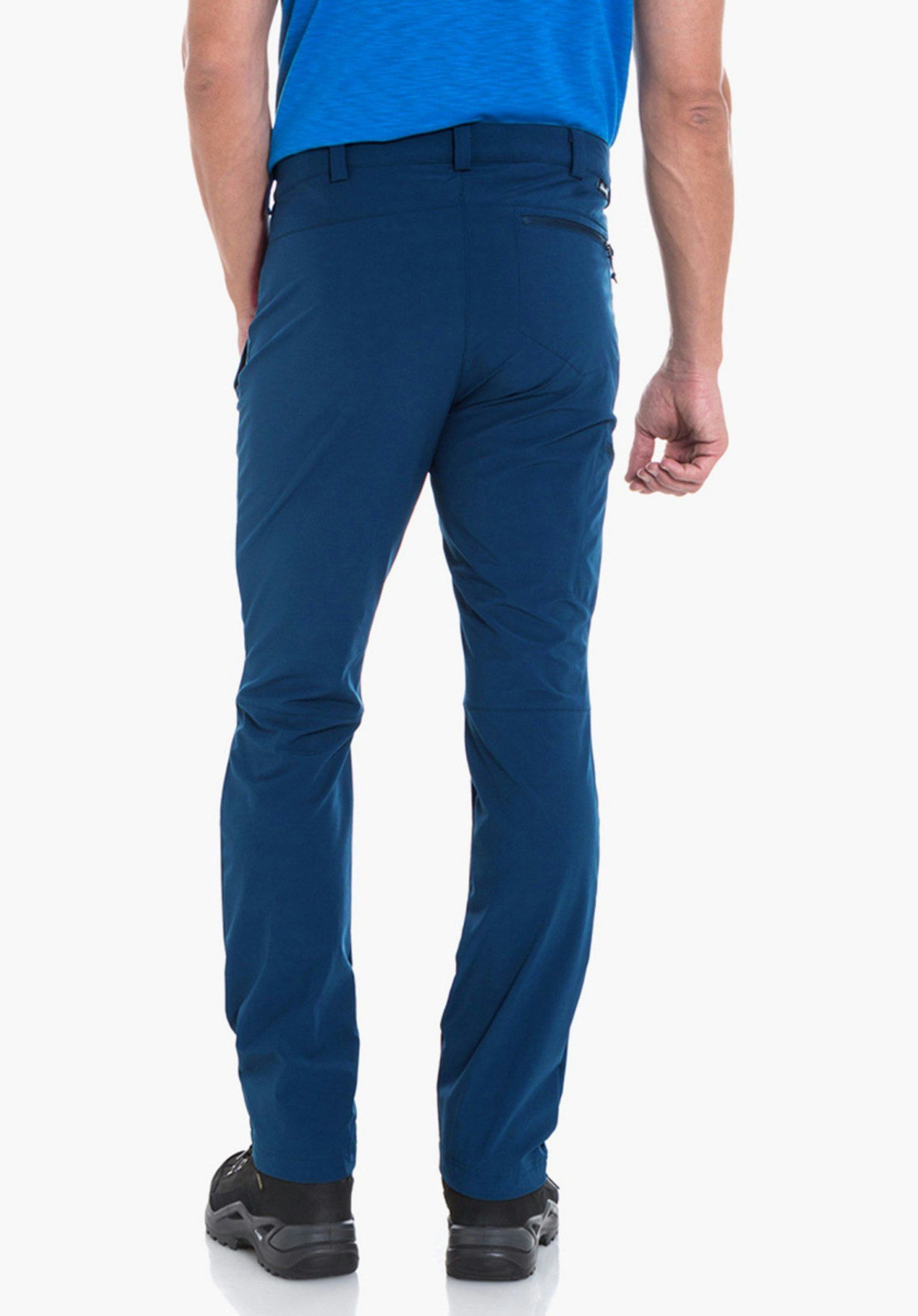 Pants Folkstone man standing with his back to the camera; wearing a light blue T-shirt, dark blue trousers and black shoes; white studio background.