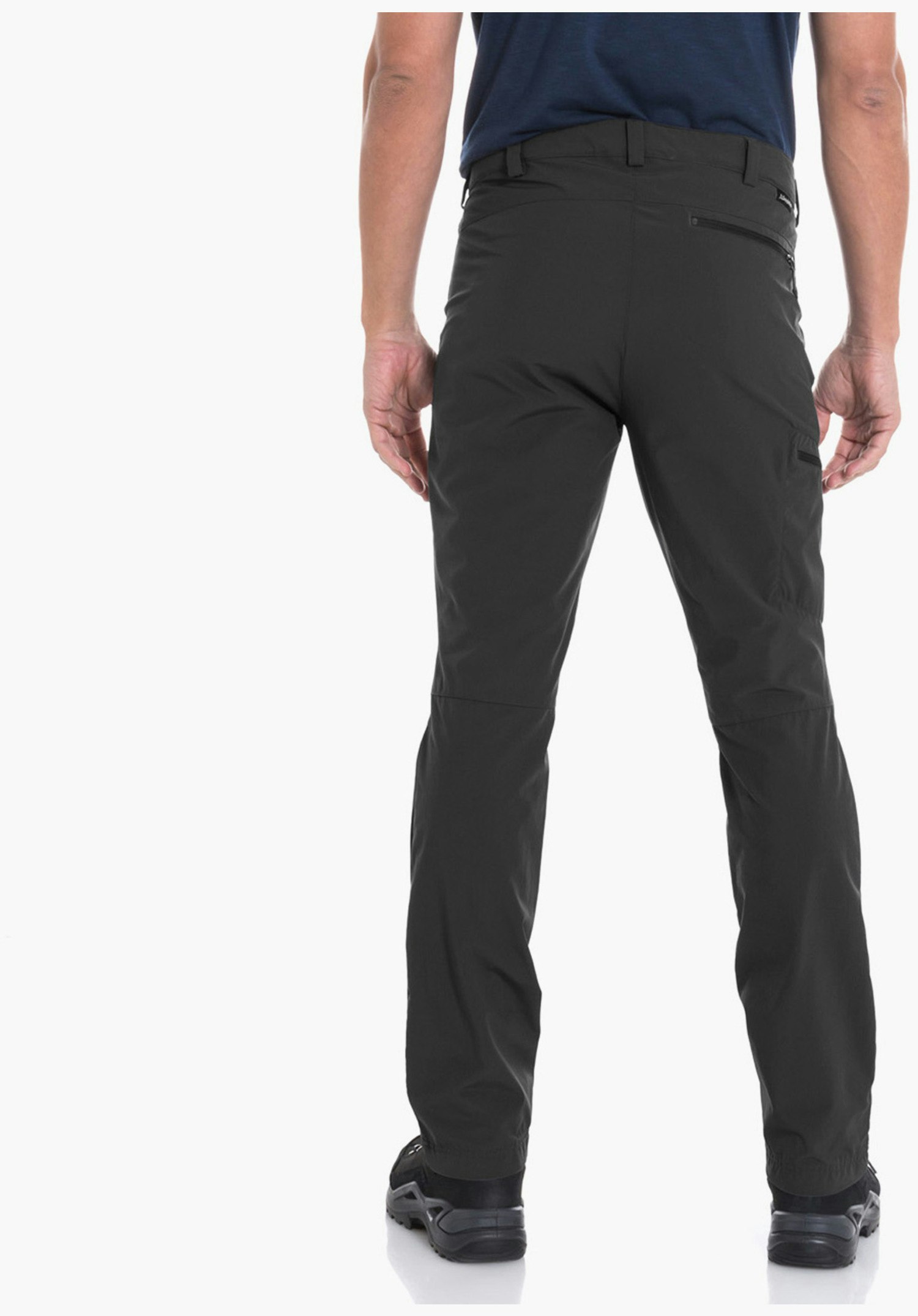 Pants Folkstone man standing with his back to the camera, looking slightly left; wearing a dark blue T-shirt, dark green trousers and black shoes; white studio background.