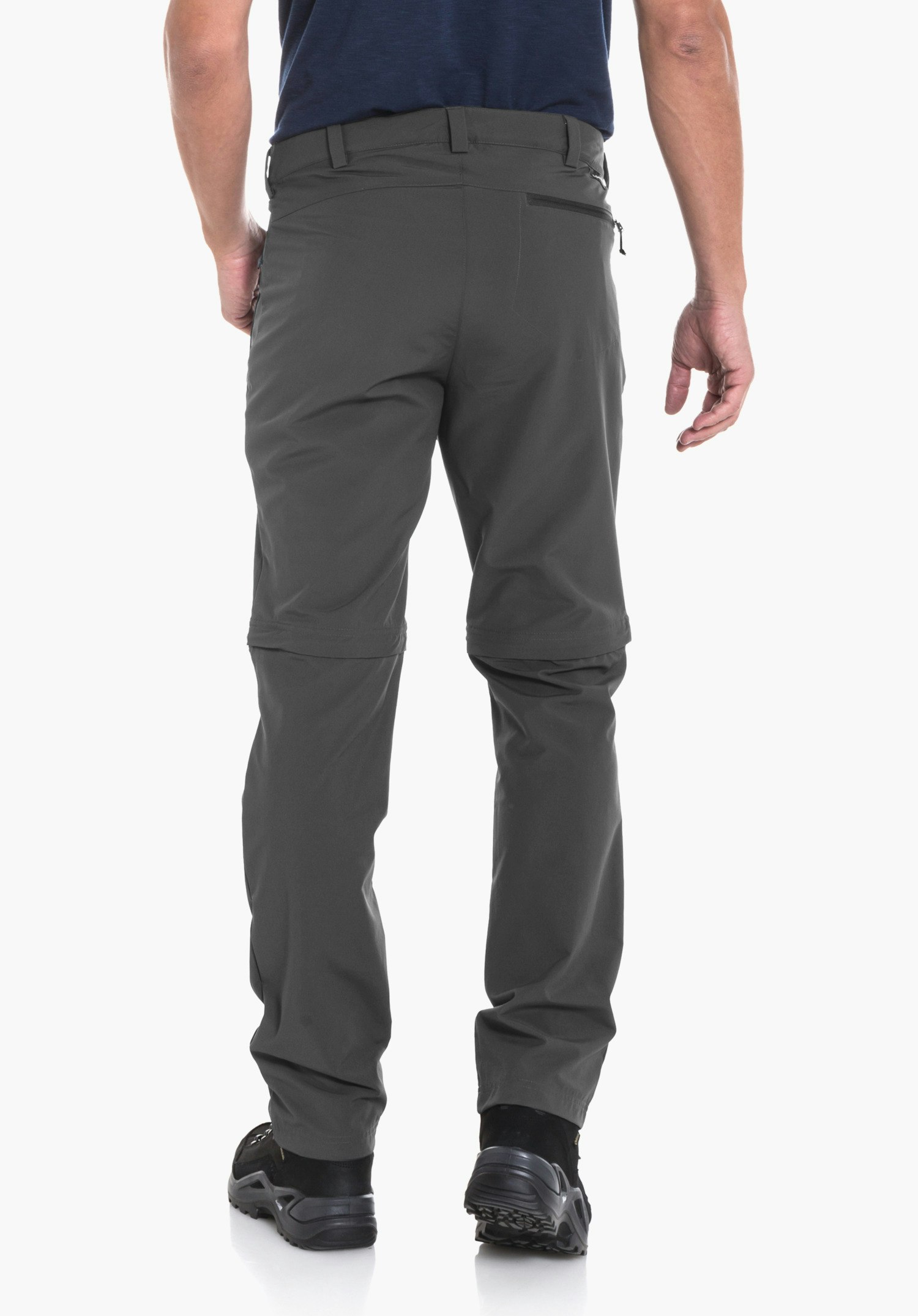 Pants Folkstone Zip Off man standing with his back to the viewer, looking over his right shoulder; wearing a dark blue T-shirt, dark green long trousers and black shoes; white studio background.