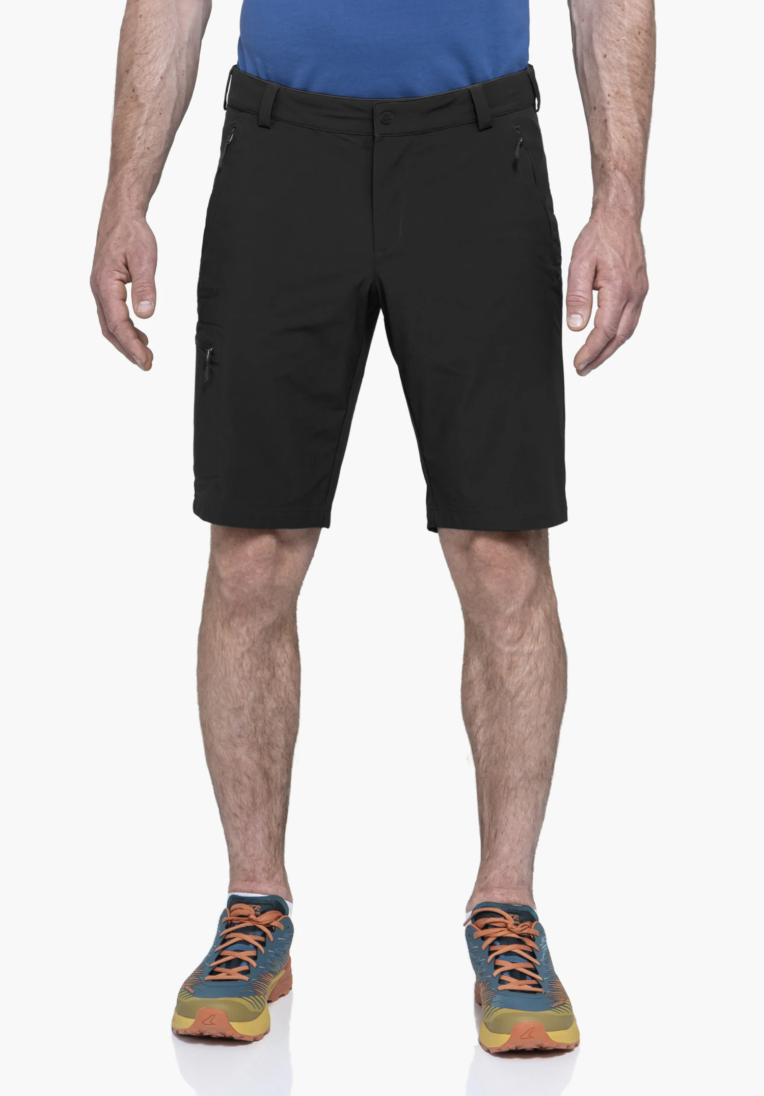 Shorts Folkstone in black, worn by a model standing facing forwards. The shorts feature side zip pockets and a subtle Schöffel logo on the right leg. Presented against a neutral background.
