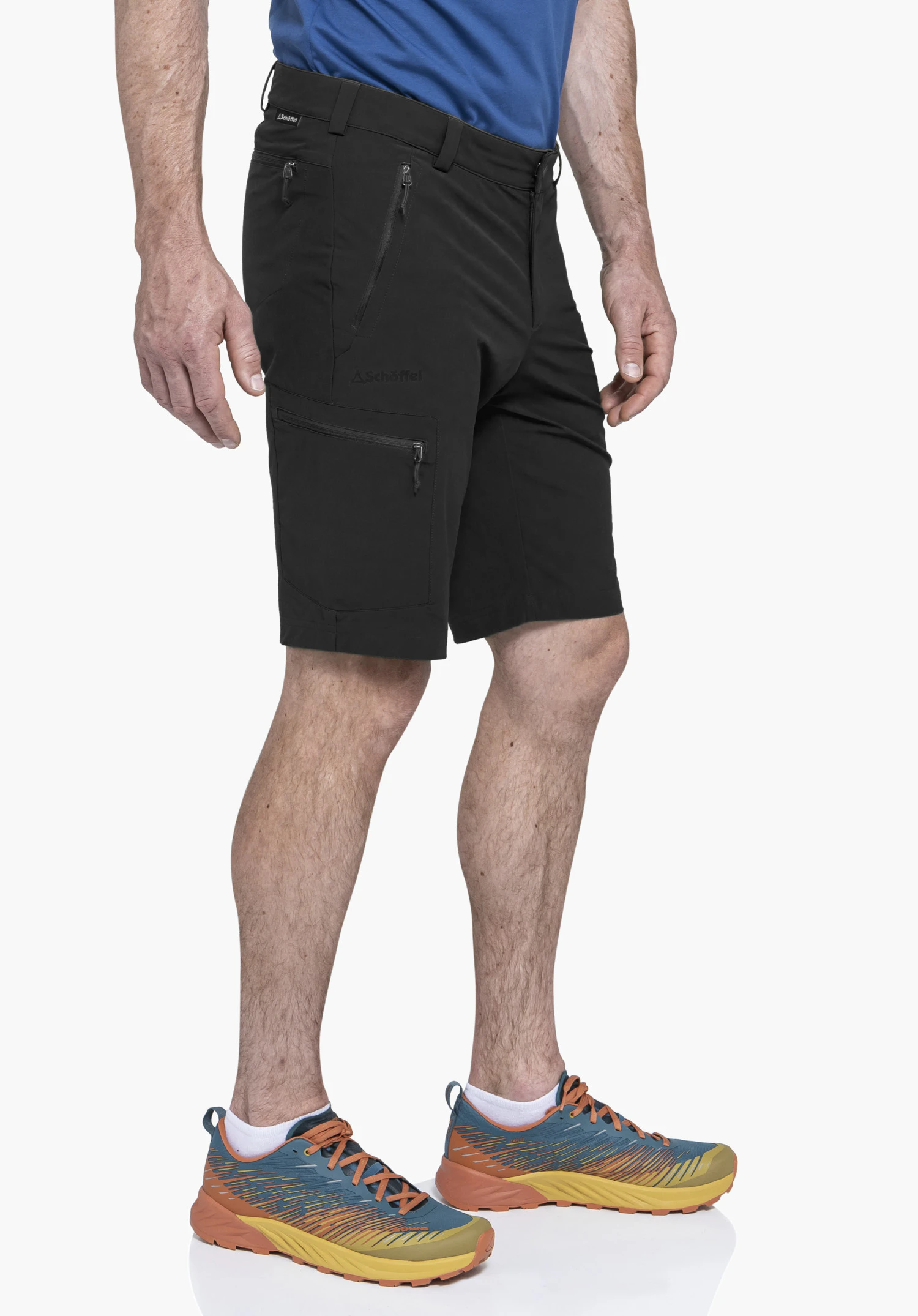 Shorts Folkstone in black. A model stands in a side profile against a neutral background showcasing the shorts. The subtle Schöffel logo is clearly visible on the thigh.