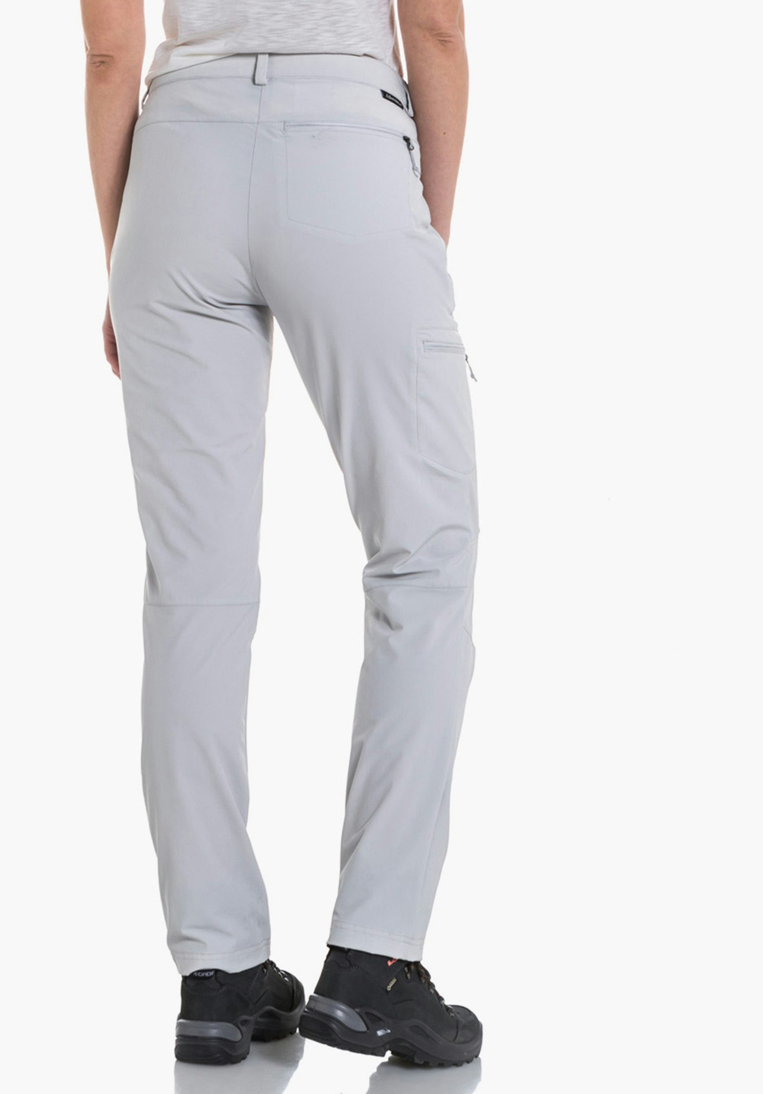 Pants Ascona light grey trousers worn by a woman standing with her back to the camera, hands in pockets; wearing a white T-shirt and black shoes; neutral white background.