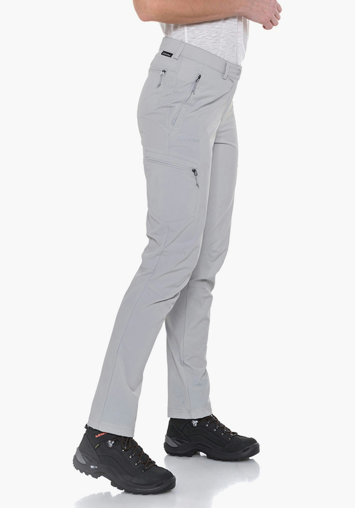 Pants Ascona women’s trousers; woman stands side-on wearing light grey trousers, white T-shirt and black hiking shoes; calm pose, looking forward, neutral white background.