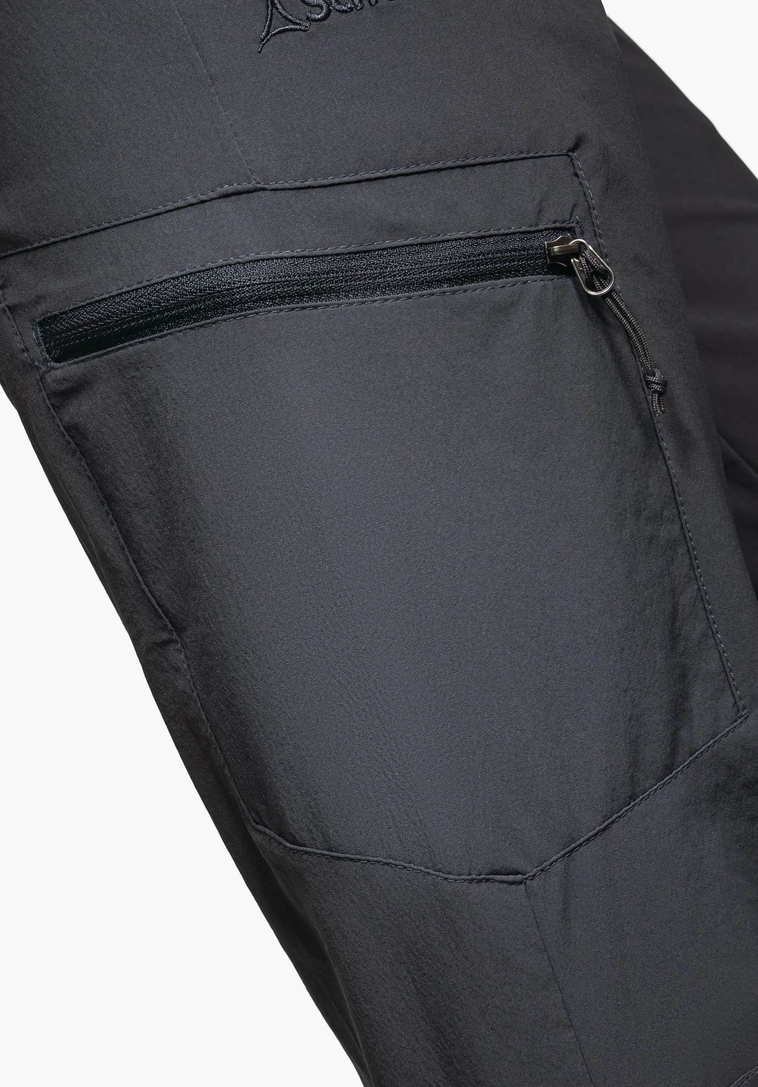 Pants Ascona shows the water-repellent grey fabric surface with beading water droplets, a waterproof zipper and the Schöffel logo in a close-up against a white/neutral background.