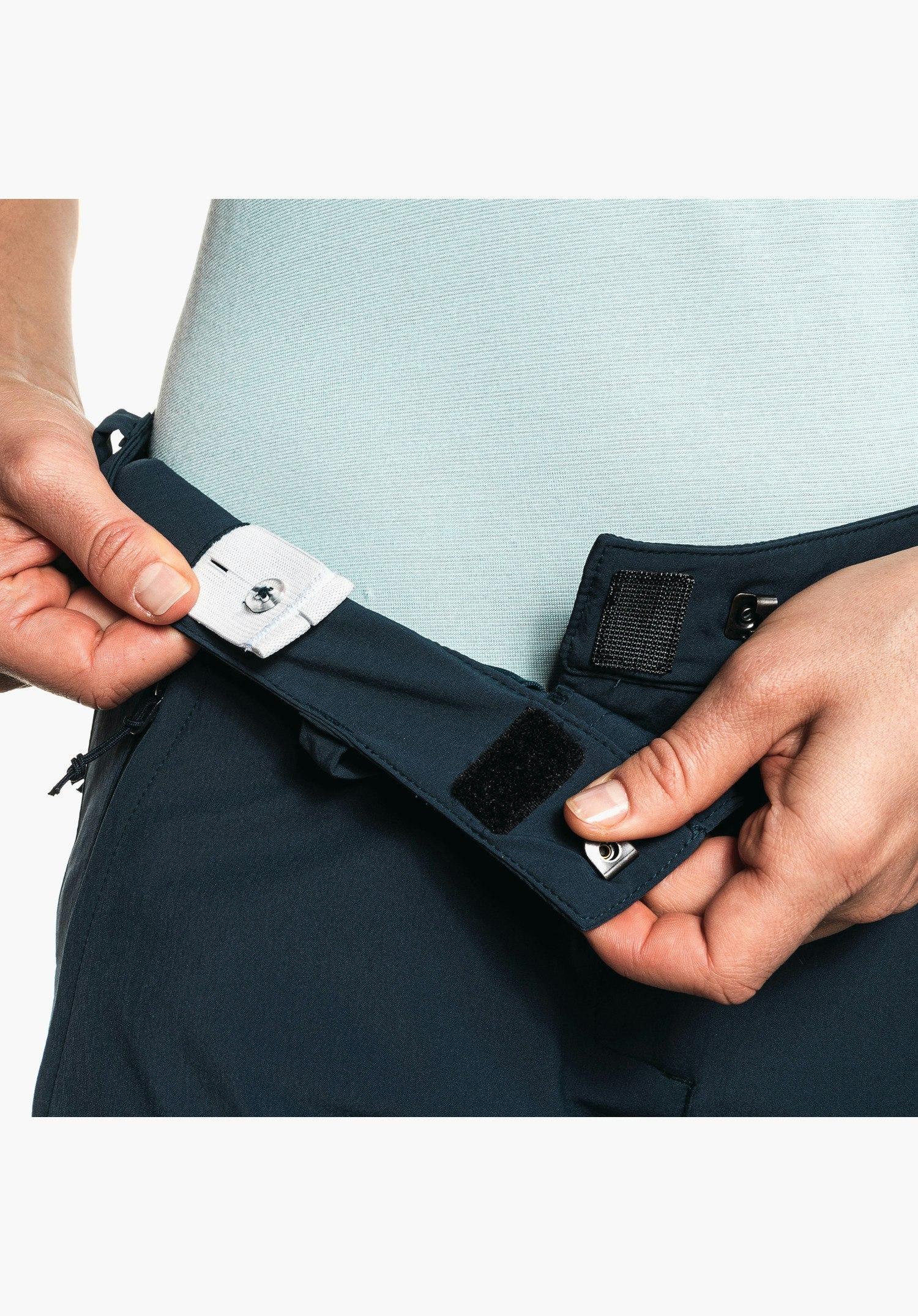 Pants Ascona Zip Off displays the adjustable waistband with internal buttonhole elastic for individual size adjustment in blue. Close-up against a neutral background.