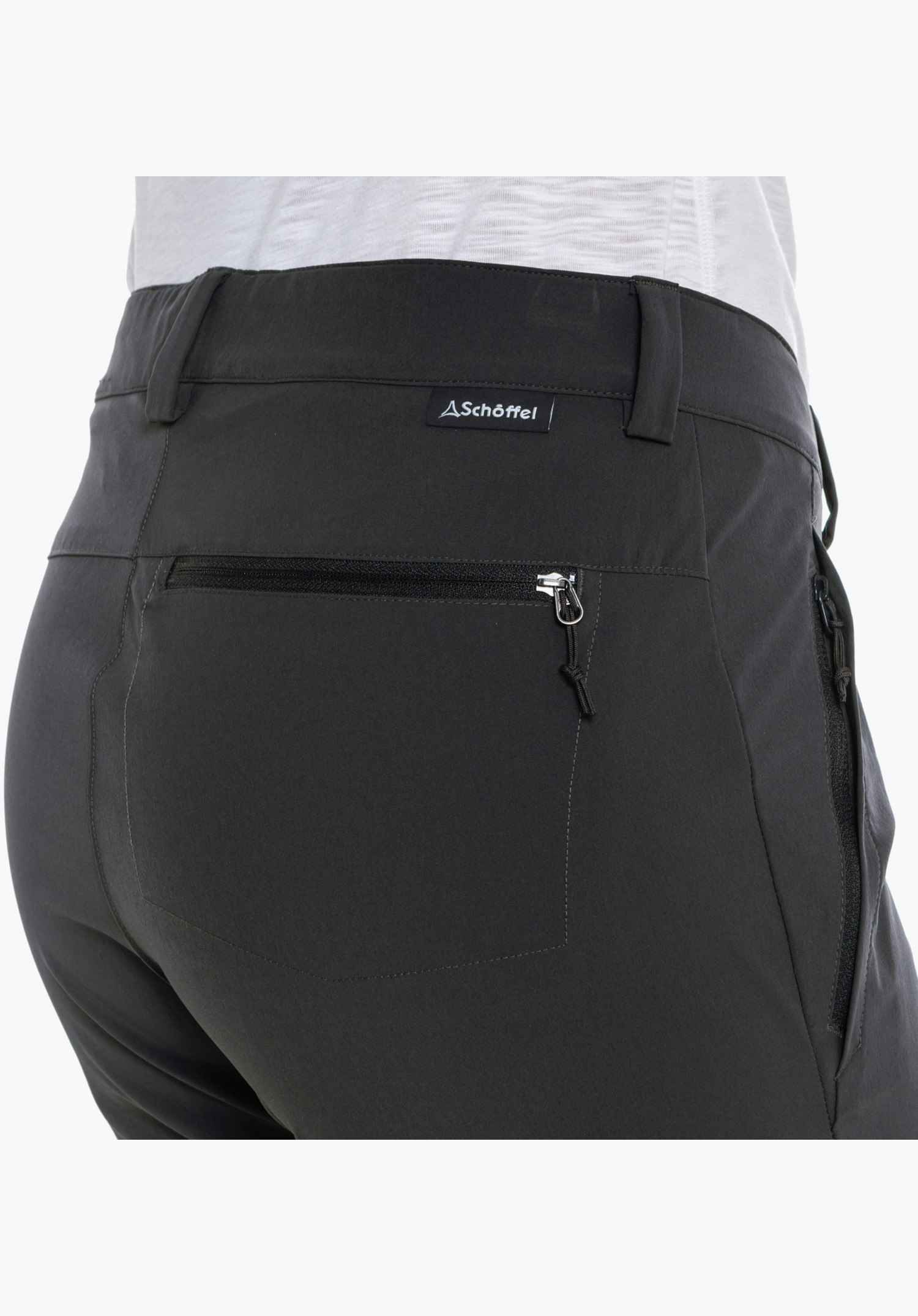 Pants Ascona Zip Off, Detailansicht der rechten Gesäßtasche mit Reißverschluss und dem kleinen Schöffel-Logo-Label unterhalb des Bundes in Grau, Nahaufnahme vor weißem Hintergrund.