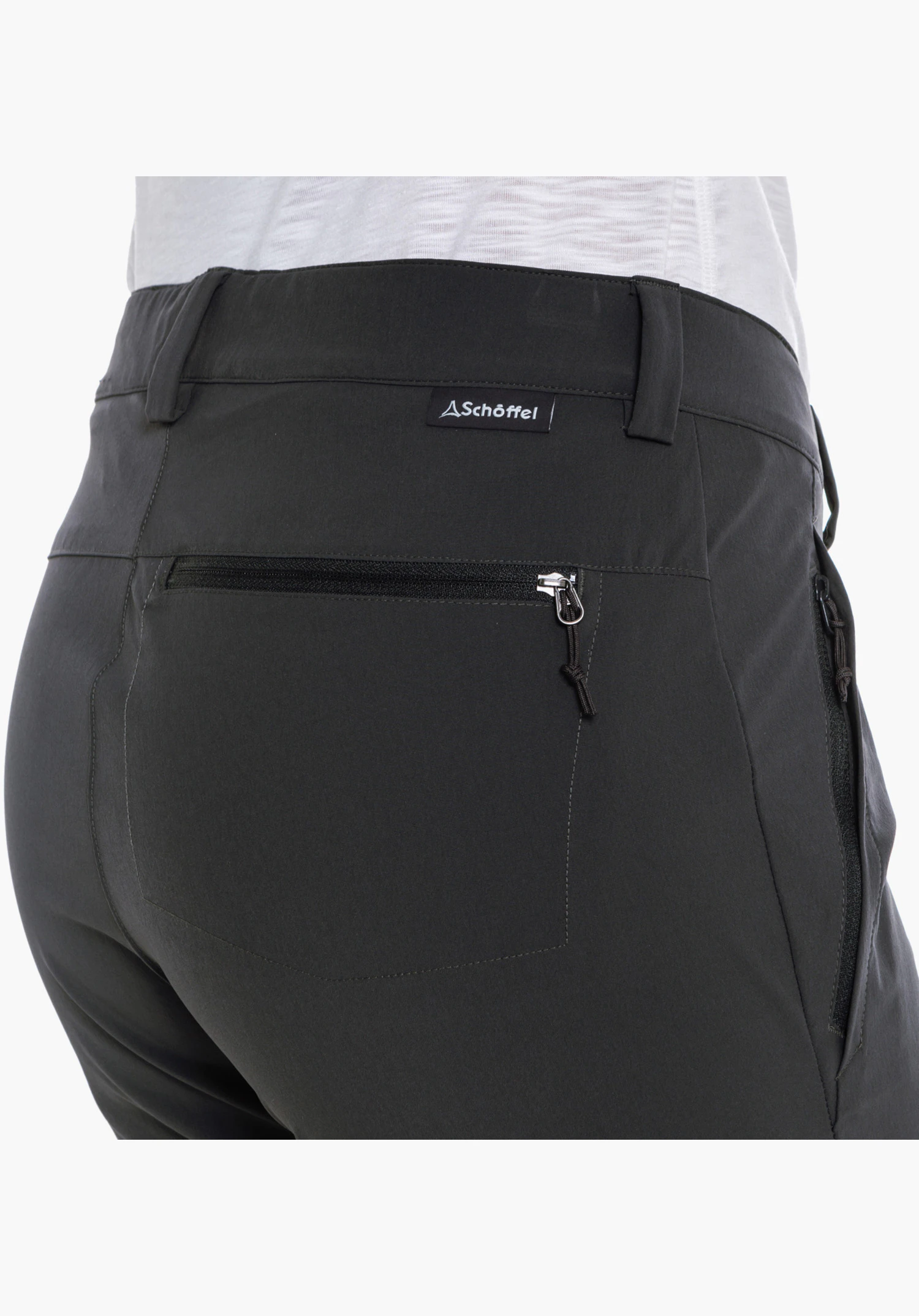 Pants Ascona Zip Off, Detailansicht der rechten Gesäßtasche mit Reißverschluss und dem kleinen Schöffel-Logo-Label unterhalb des Bundes in Grau, Nahaufnahme vor weißem Hintergrund.