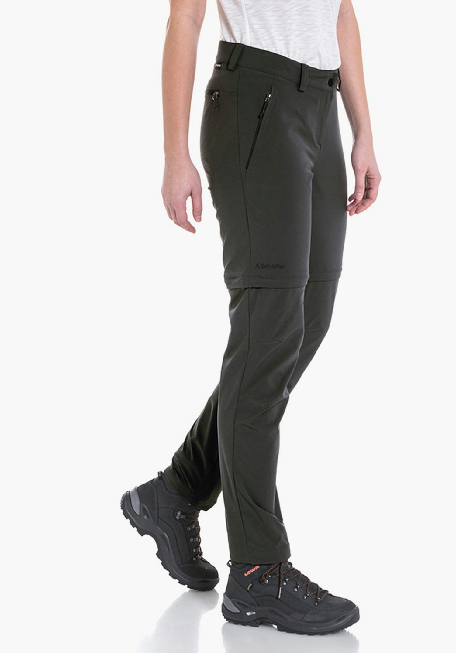 Pants Ascona Zip Off Modell in weißem T-Shirt und dunkelgrüner Hose schreitet seitlich auf weißem Hintergrund, trägt schwarze Wanderschuhe. Text auf Hose: "A.Schöffel".