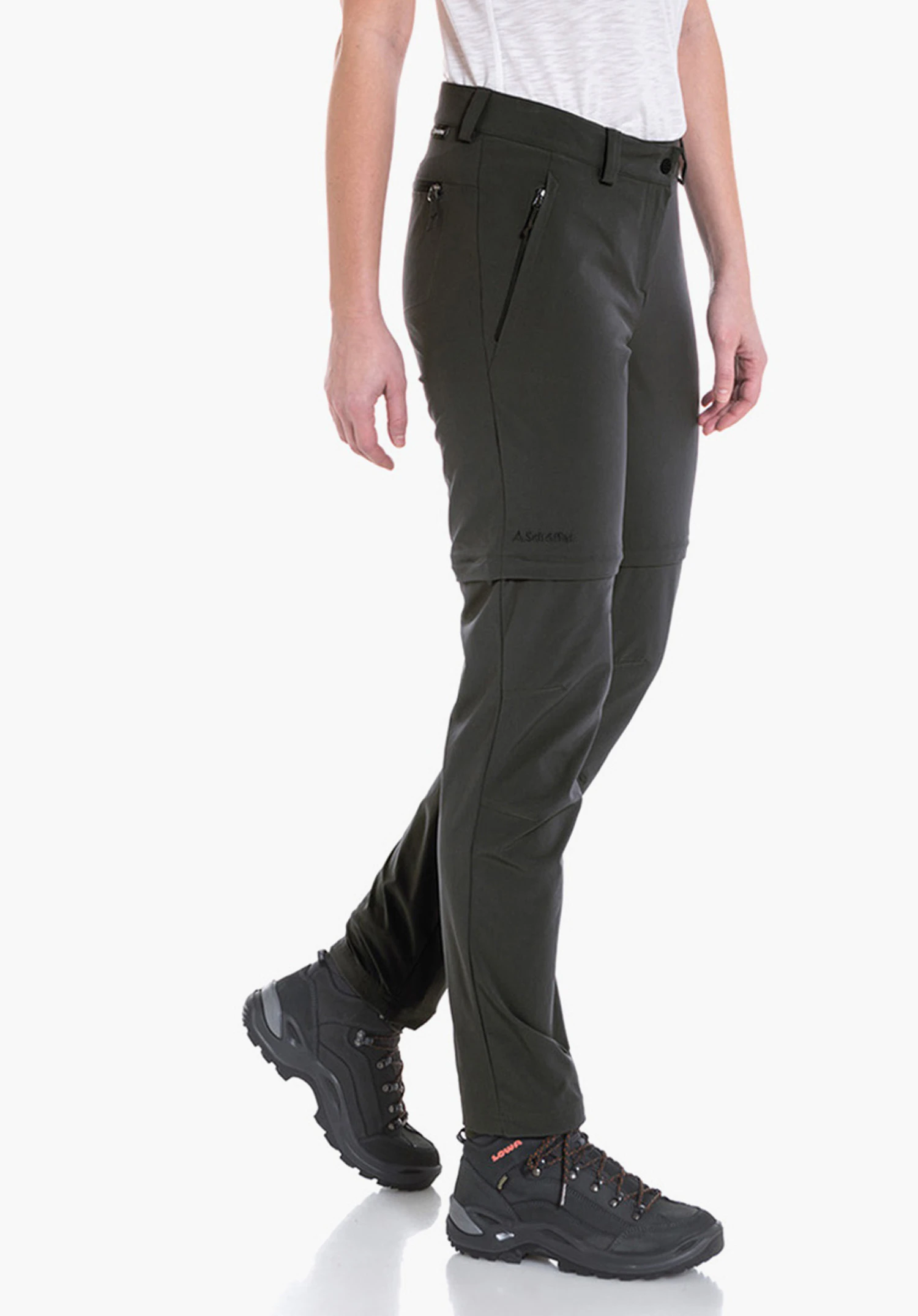 Pants Ascona Zip Off Modell in weißem T-Shirt und dunkelgrüner Hose schreitet seitlich auf weißem Hintergrund, trägt schwarze Wanderschuhe. Text auf Hose: "A.Schöffel".