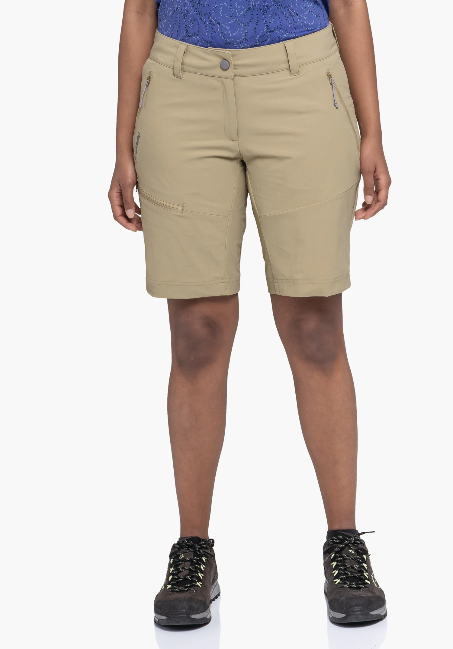 Shorts Toblach2 porté par un mannequin se tenant de face. Le short de couleur beige présente des poches latérales zippées ainsi que le logo Schöffel sur la jambe droite et est présenté sur un fond neutre.