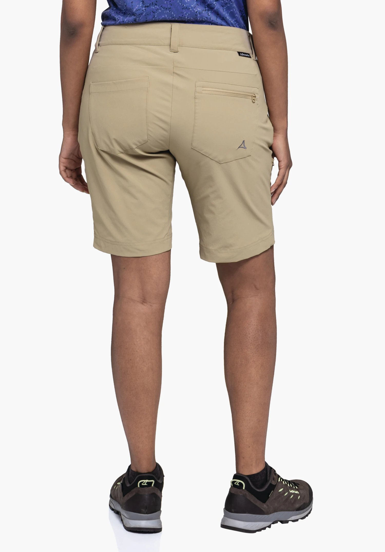 Shorts Toblach2 porté par un mannequin vu de dos. Le short beige présente deux poches arrière et un petit logo Schöffel sur la poche droite. Le mannequin se tient devant un fond neutre.