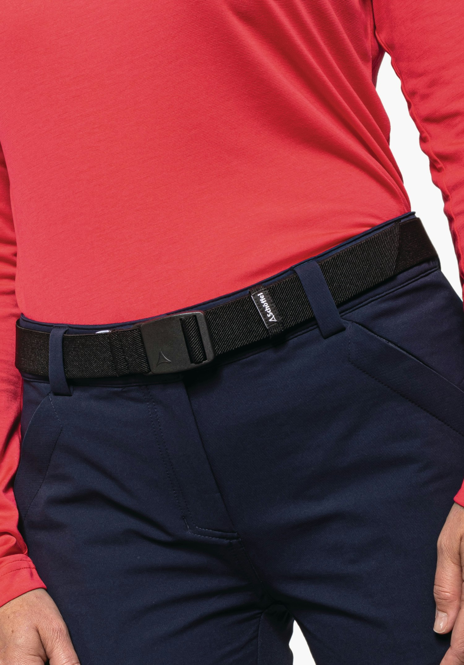 Belt Lenzerheide1 black belt with Schöffel logo on the buckle, worn around the waist holding dark blue trousers; person wears a red long-sleeve top. Label text: “Schöffel”.