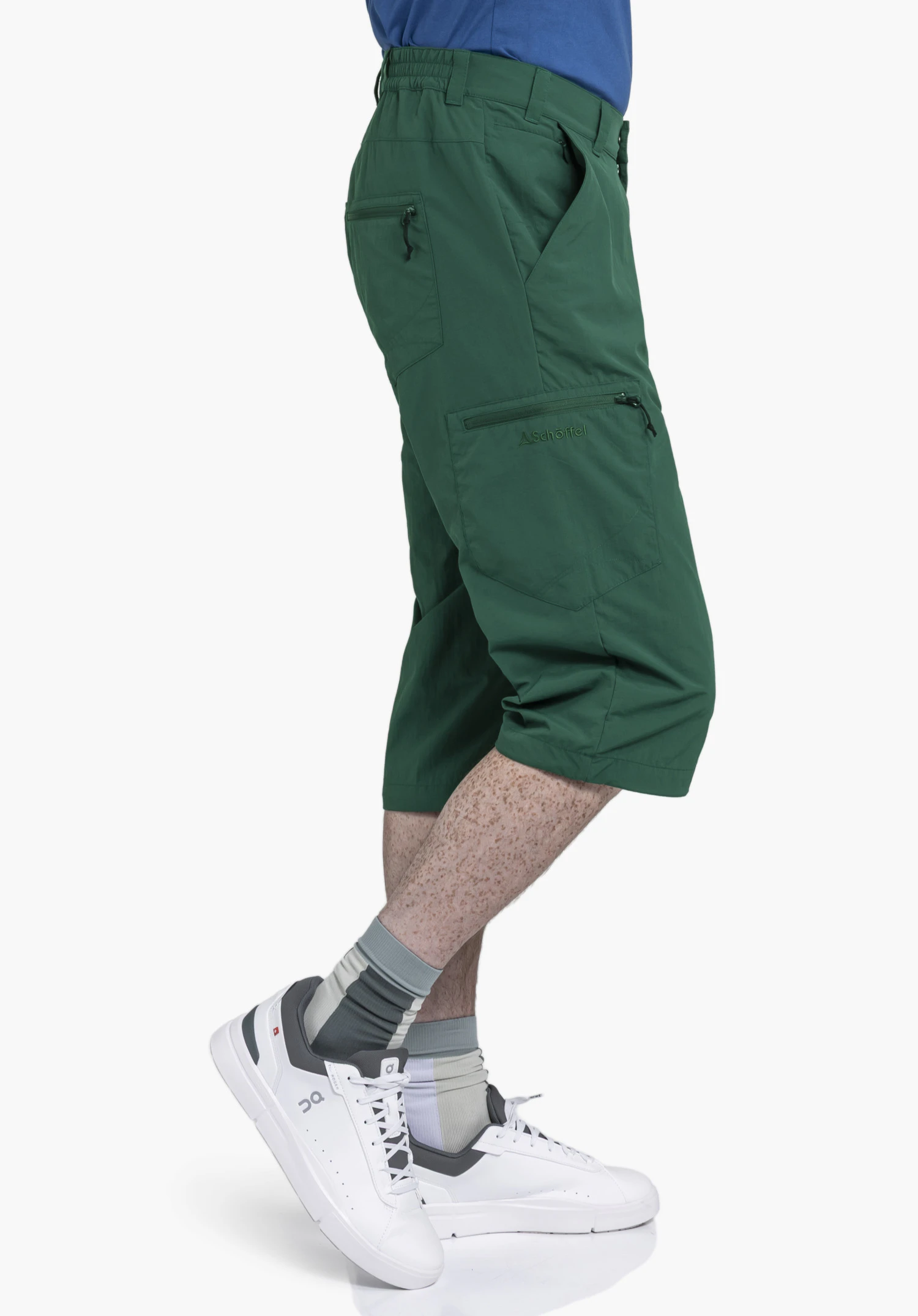 Pants Springdale1 in green: A side view shows the pants worn by a model against a neutral background. The three-quarter length trousers feature a side leg pocket with a subtle Schöffel logo.