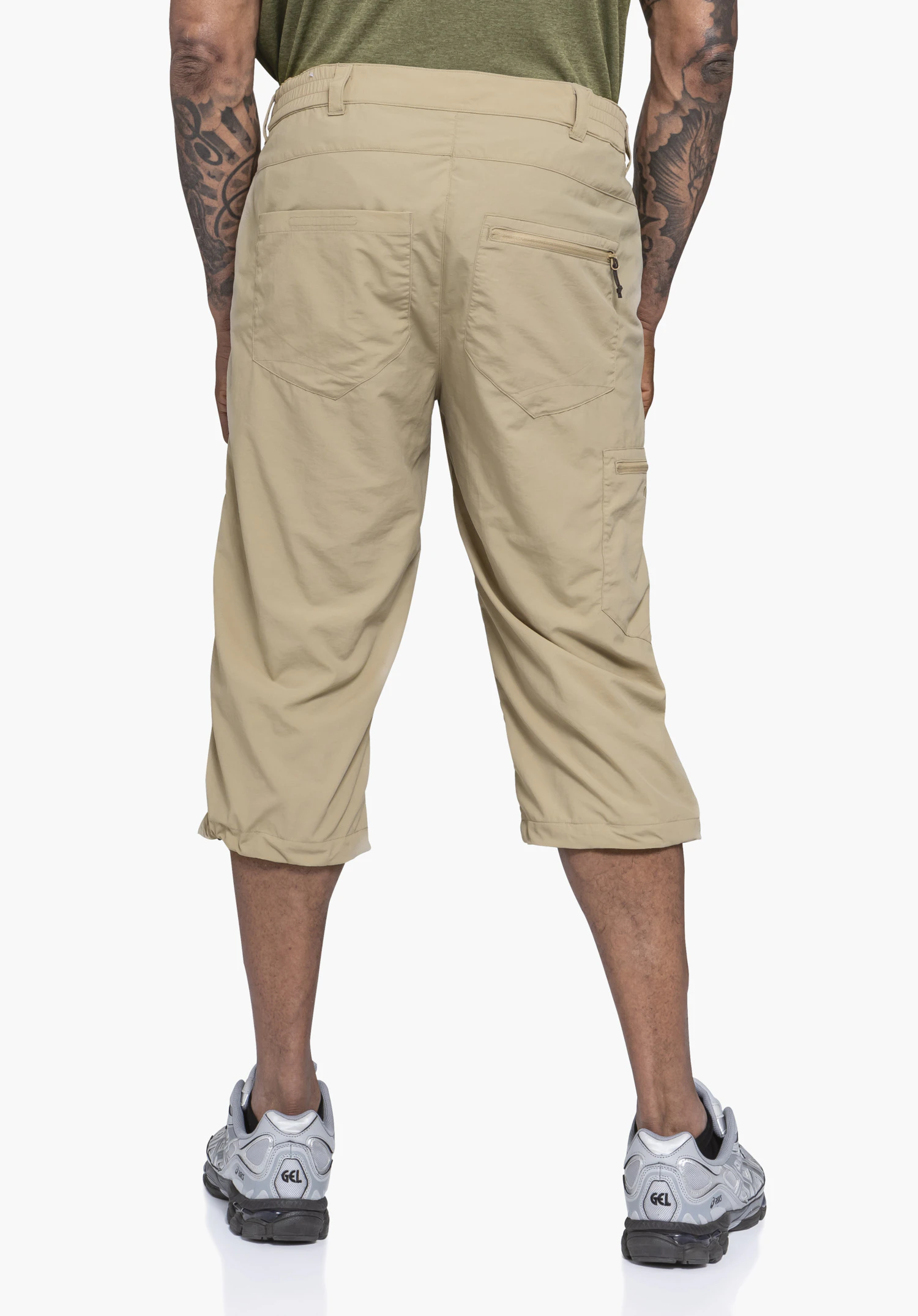 Pants Springdale1 en beige, présentée en vue arrière avec des poches zippées fonctionnelles et le logo Schöffel visible sur la poche de jambe, sur un fond neutre.