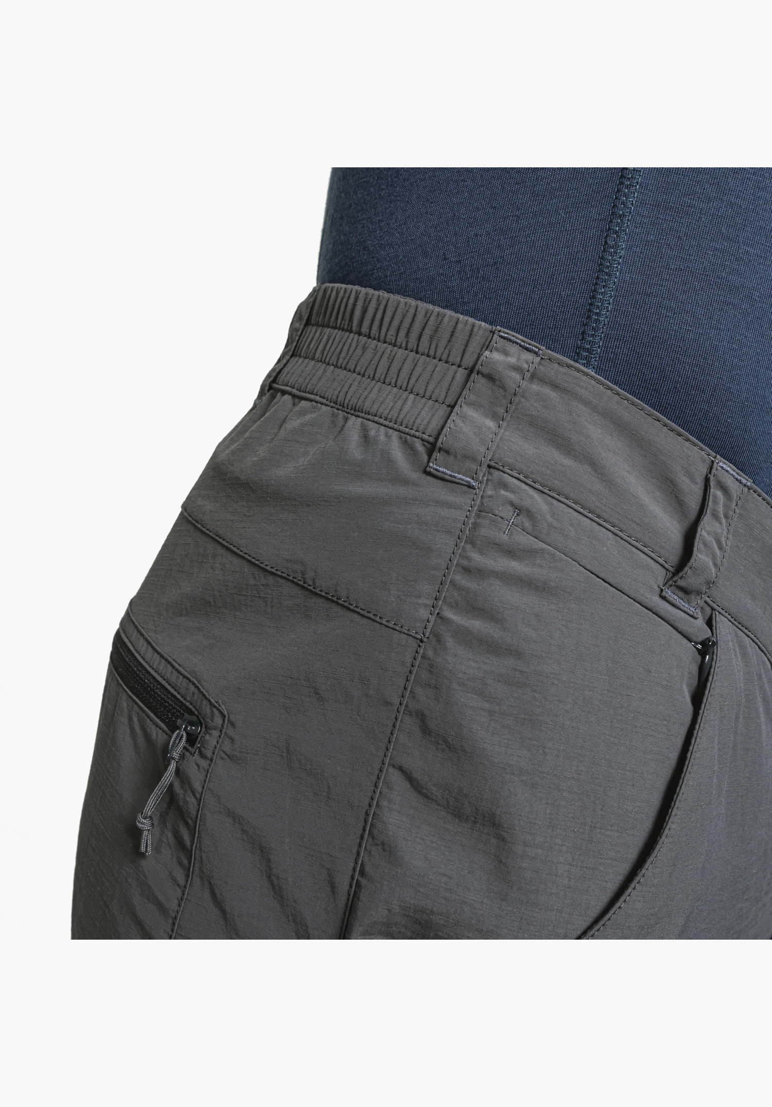 Pants Springdale1 zeigt den grauen Stoff, einen teilelastischen Bund mit Gürtelschlaufen sowie eine Reißverschlusstasche mit Kordelzipper, Nahaufnahme vor weißem/neutralem Hintergrund.