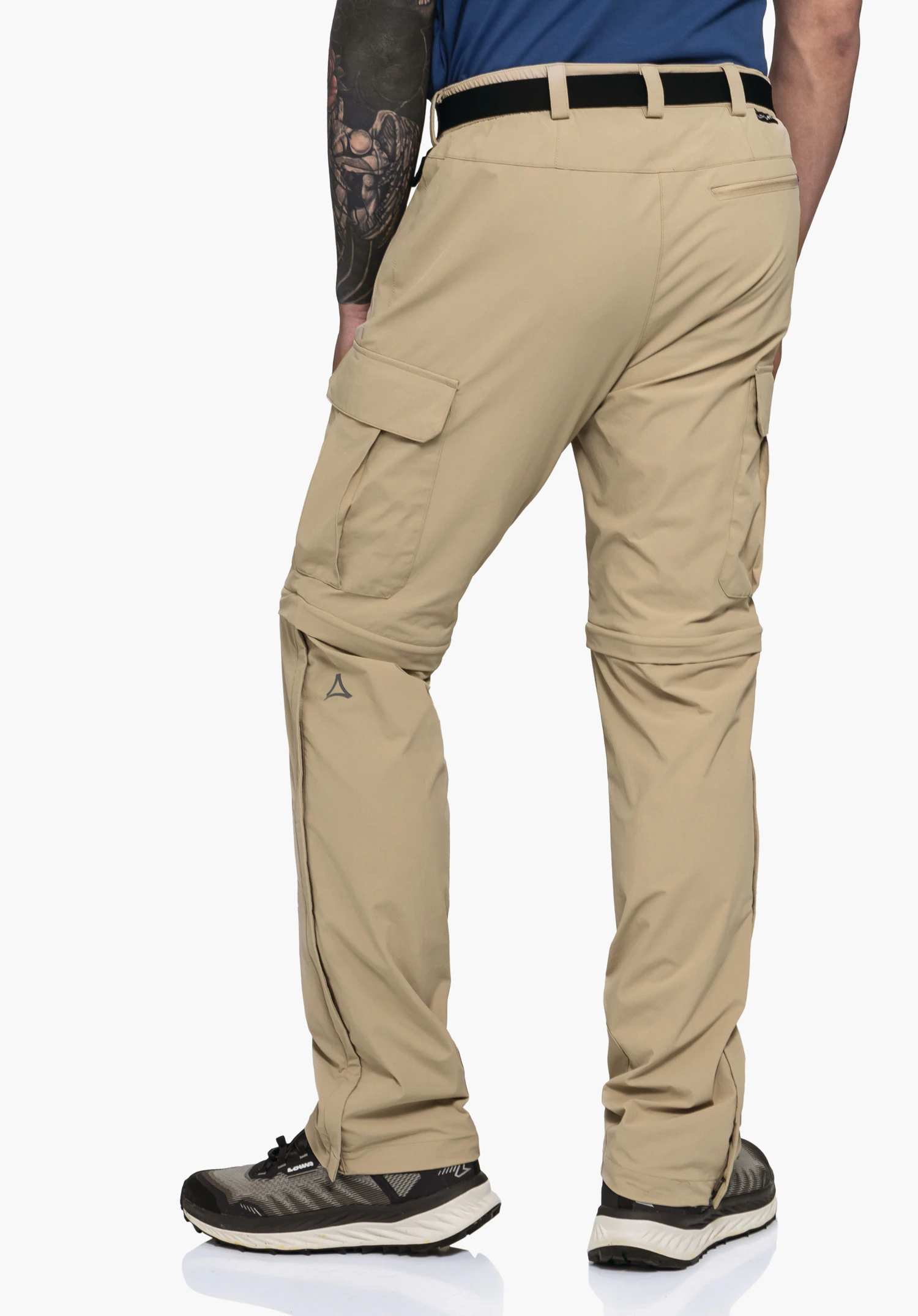 Pants Kyoto3 in der Rückansicht an einem Model in Beige, mit Fokus auf die Cargotaschen, die Zipp-off-Funktion sowie das Schöffel-Logo vor einem neutralen Hintergrund.
