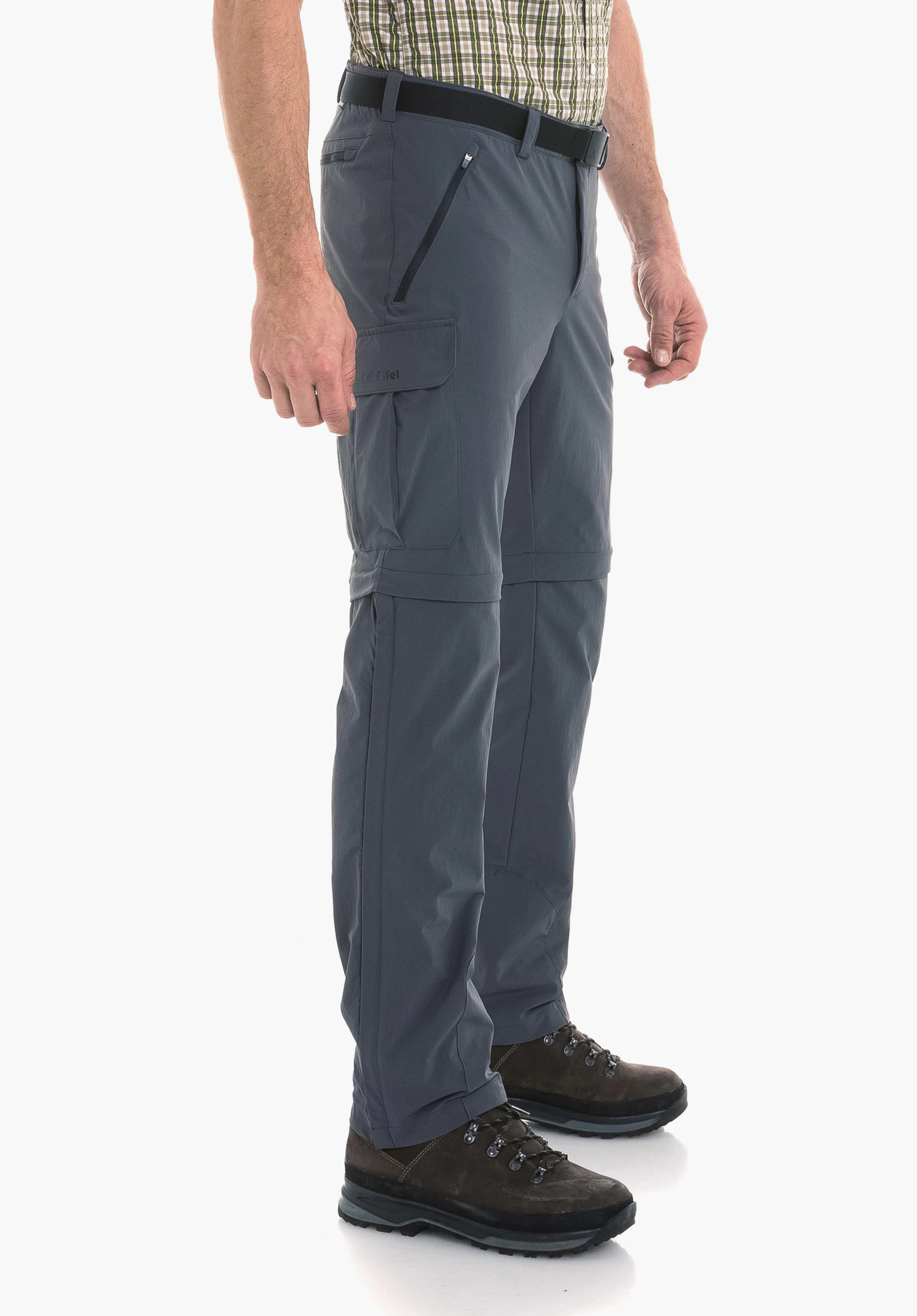 Pants Kyoto3 in grijs. Een model staat zijwaarts op een neutrale achtergrond en presenteert de functionele broek. Het subtiele Schöffel-logo is zichtbaar op de zak op het been.