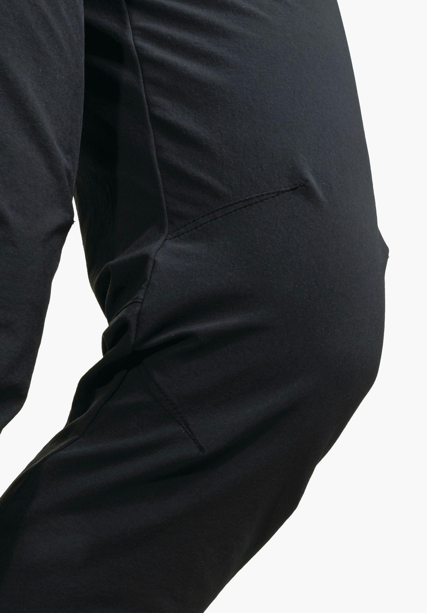 Pants Engadin1 showing the pre-shaped knee area of the black trousers for optimal freedom of movement in a close-up against a white background.