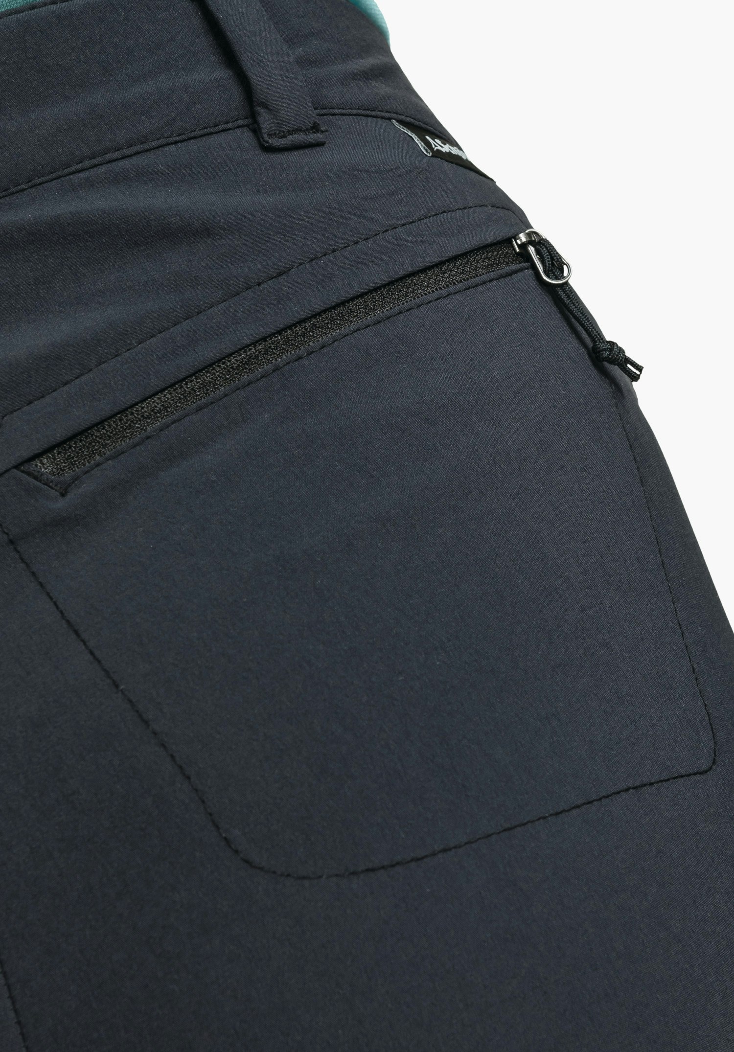 Pants Engadin1 showing a zipped pocket on the black fabric and a small Schöffel logo on the waistband, close-up against a white/neutral background.