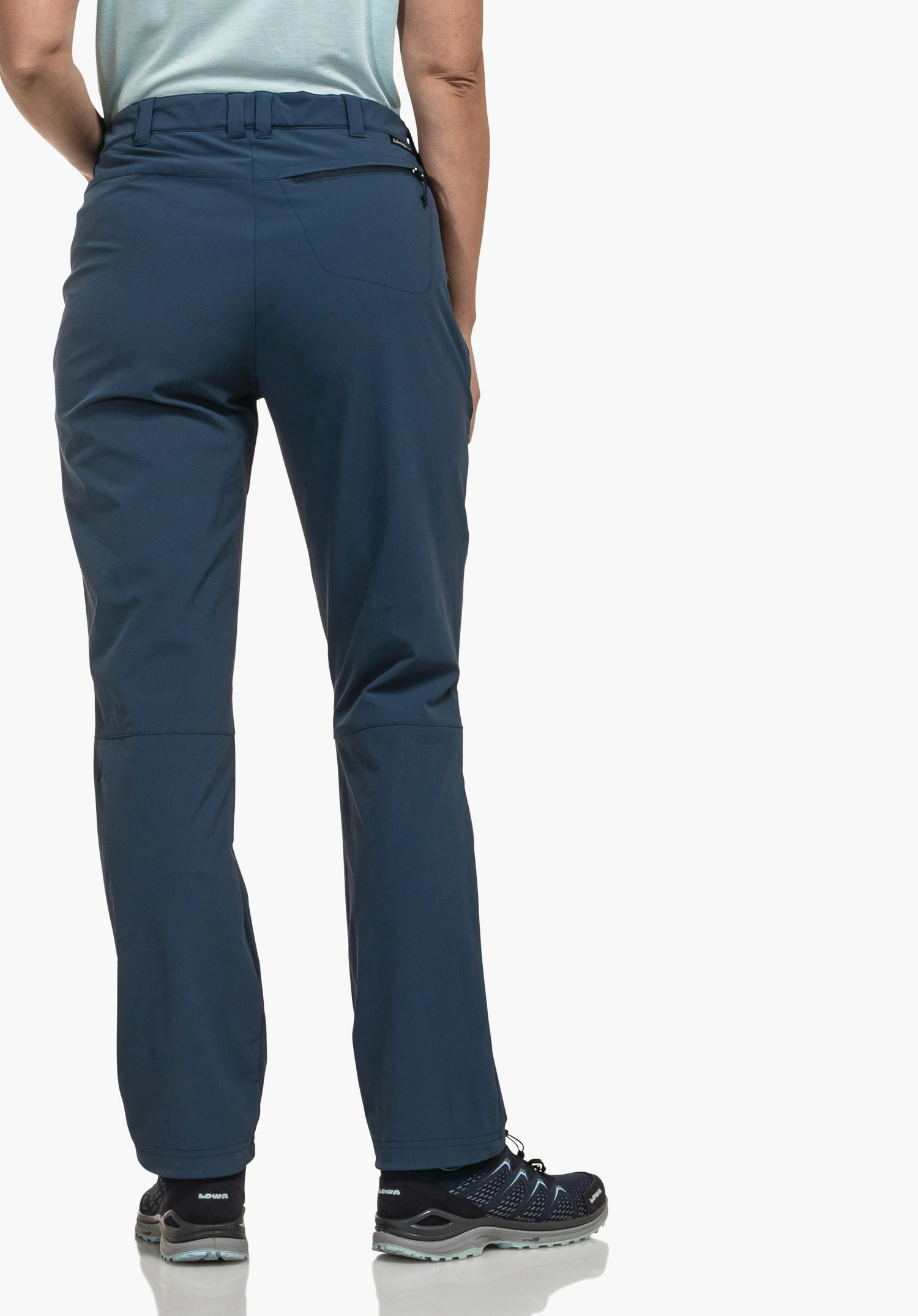 Pants Engadin1 dark blue trousers worn by a standing person from the back; hands at the sides, light blue top, dark blue trekking shoes; white studio background.