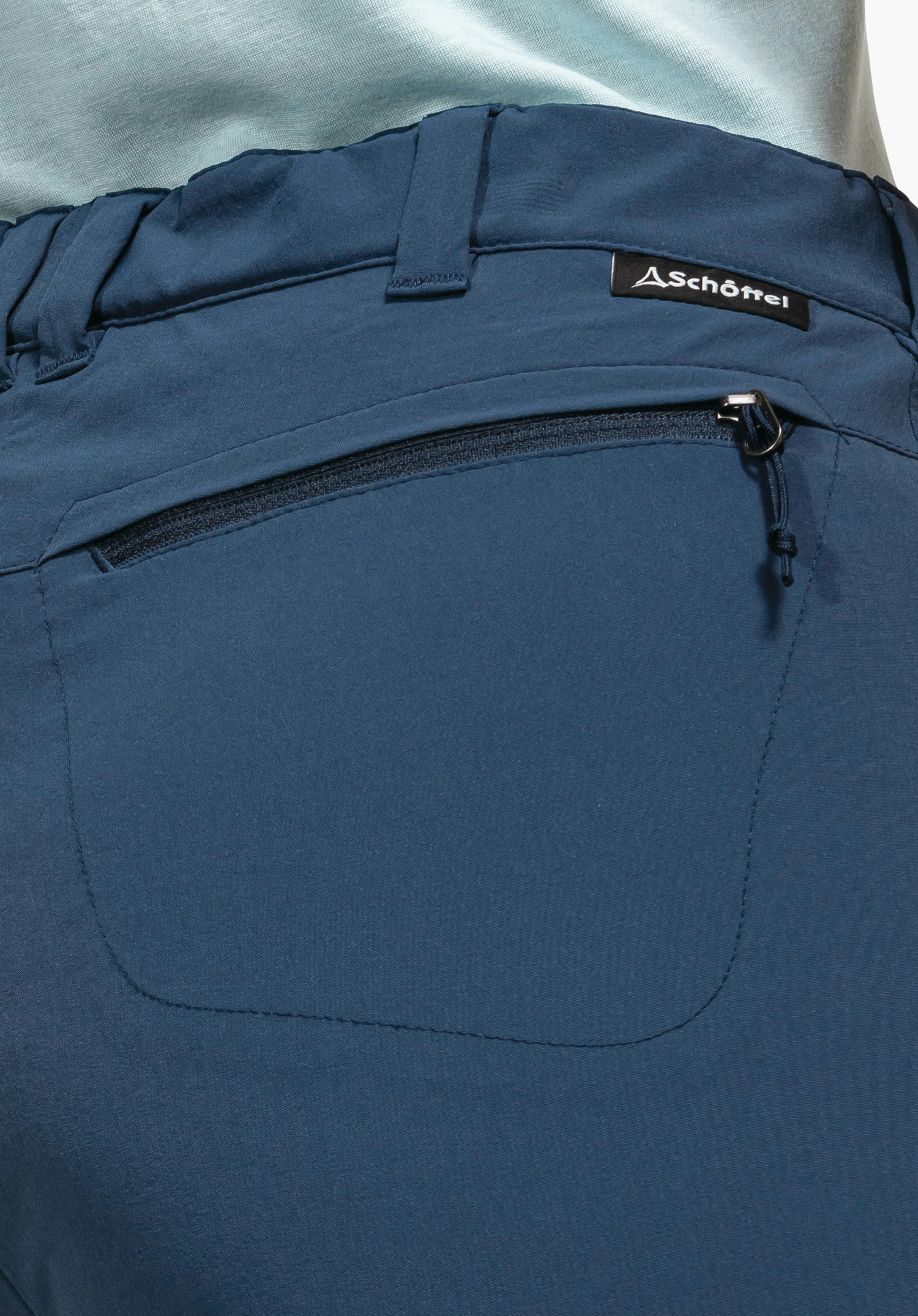 Pants Engadin1 showing the blue waistband with belt loops, a back pocket with zip and the Schöffel logo label, close-up against a white/neutral background.