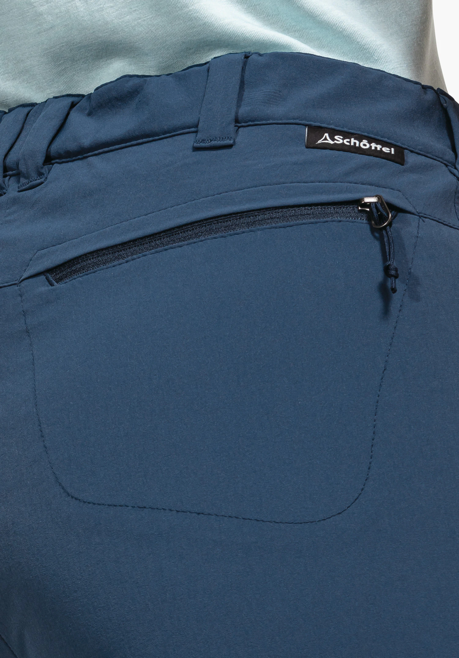 Pants Engadin1 showing the blue waistband with belt loops, a back pocket with zip and the Schöffel logo label, close-up against a white/neutral background.