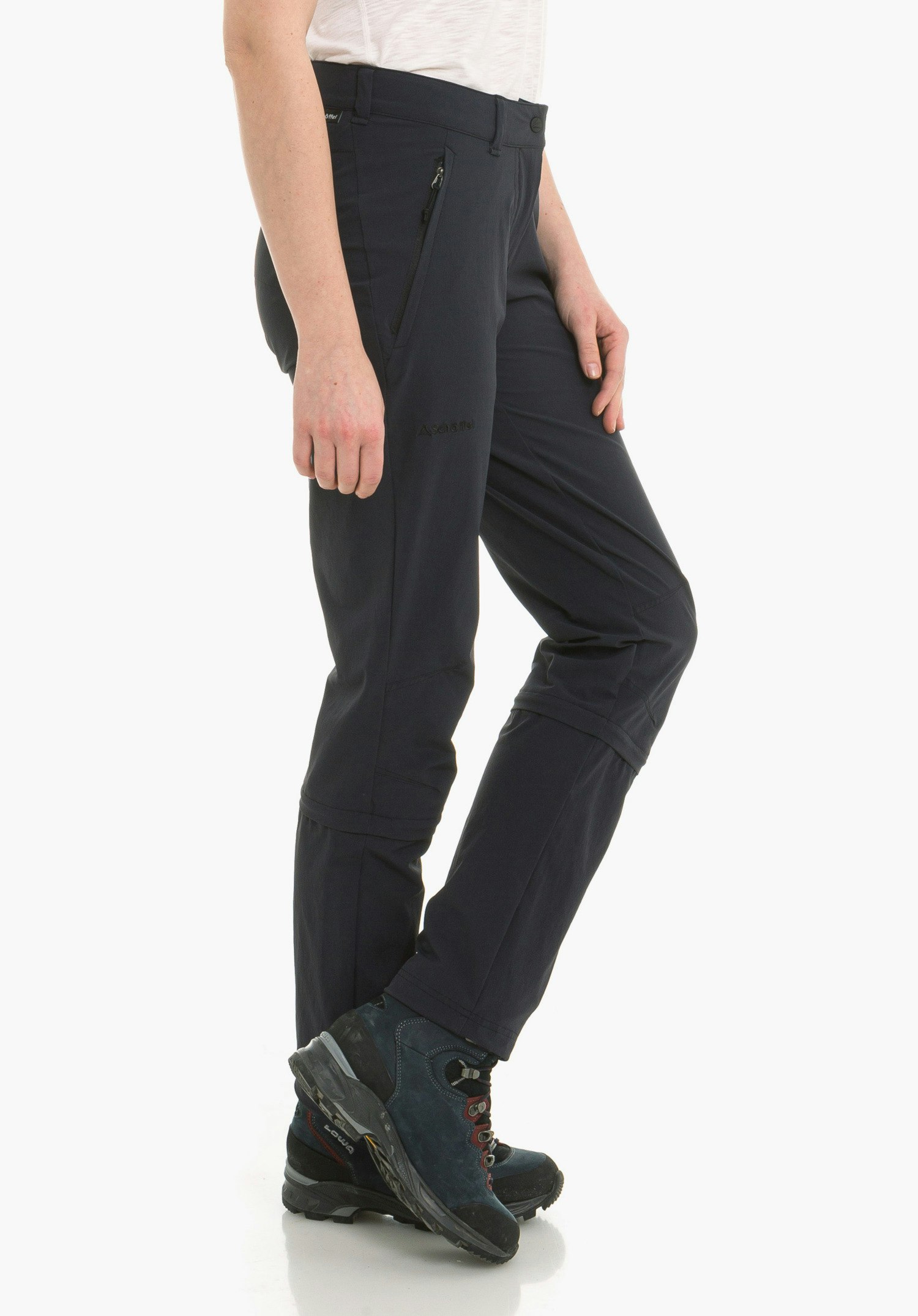Pants Engadin1 Zip Off dark blue hiking trousers, standing side-on with right leg slightly bent; visible white shirt, dark blue hiking boots with red laces on a white background. Text on shoe: "LOWA".