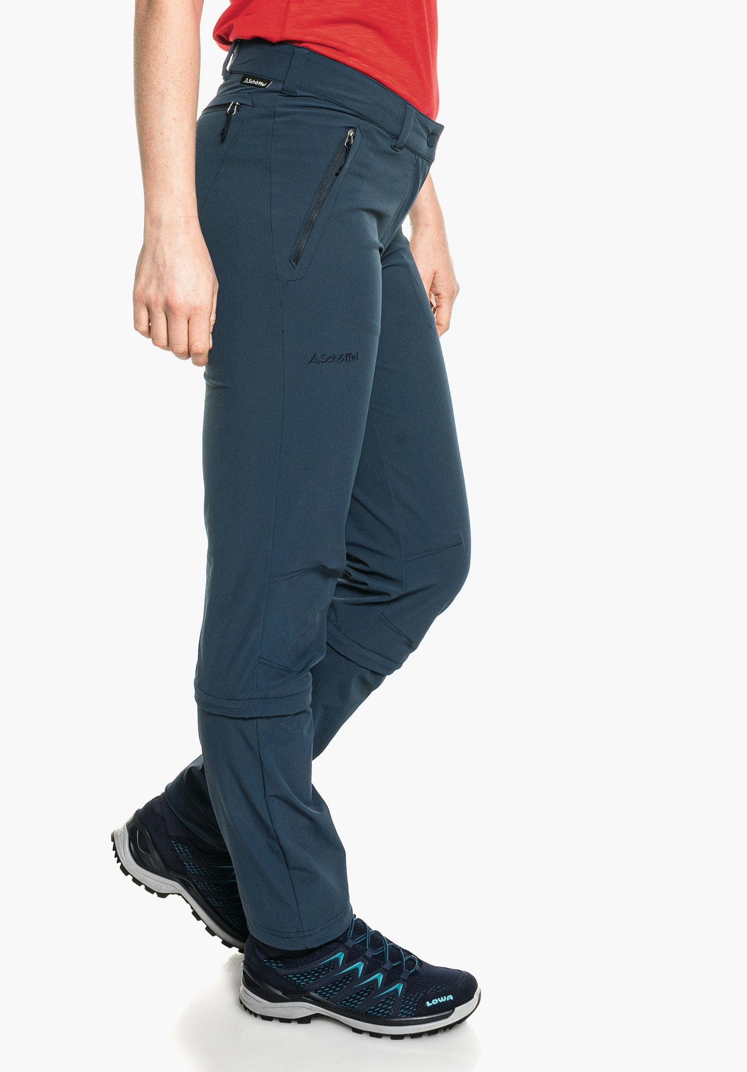 Pants Engadin1 Zip Off dark blue hiking trousers worn side-on by a person standing in front of a white background; Schöffel logo and lettering "Schöffel" visible on the thigh; shoe with text "LOWA".