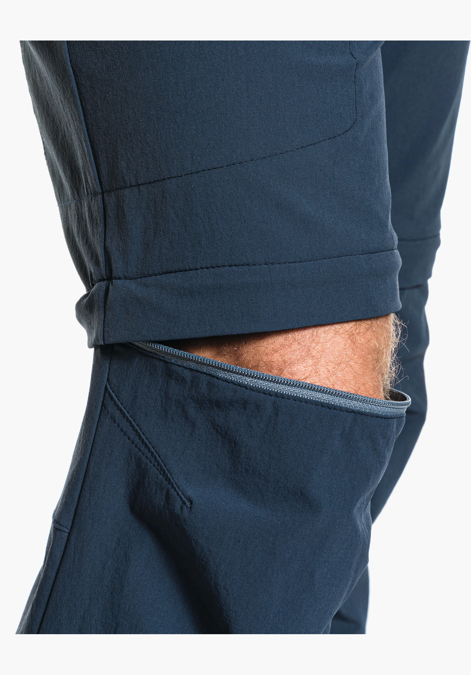 Pants Koper1 Zip Off showing the partially open zip on the blue trouser leg, demonstrating the zip-off function above the knee. Close-up against a white background.