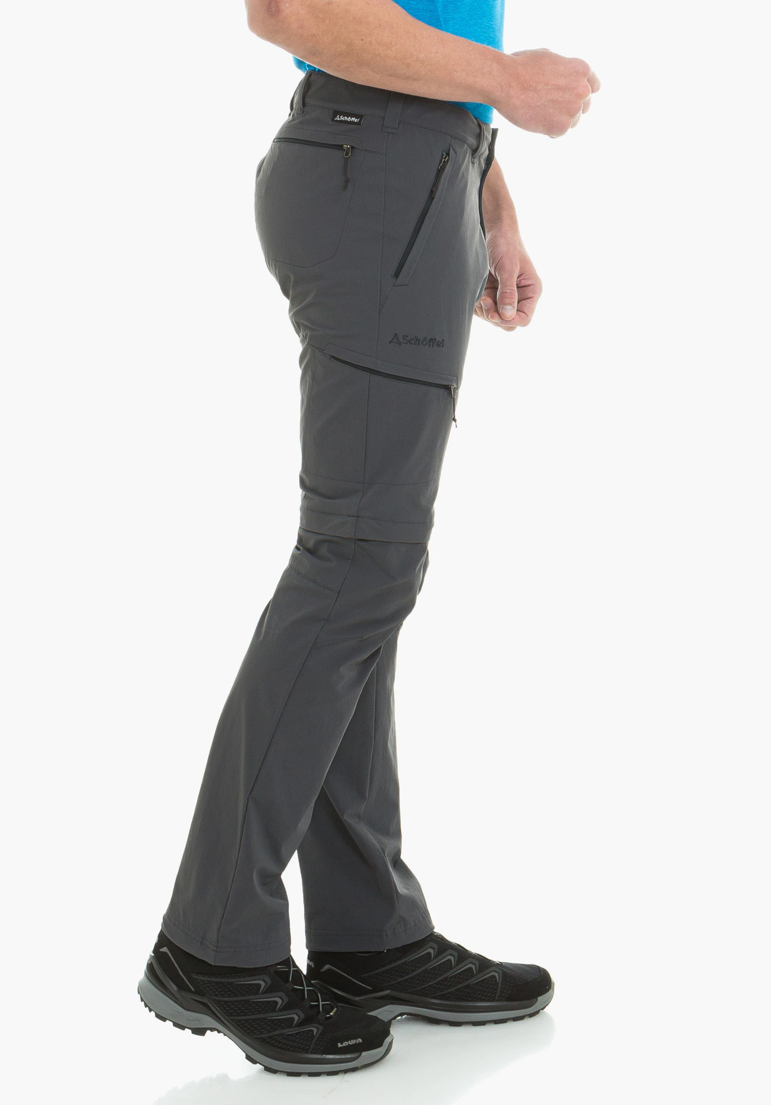 Pants Koper1 Zip Off dark grey outdoor trousers worn by a standing person with a light blue shirt and black hiking boots; side zip pockets, Schöffel logo, text: "Schöffel", "LOWA".