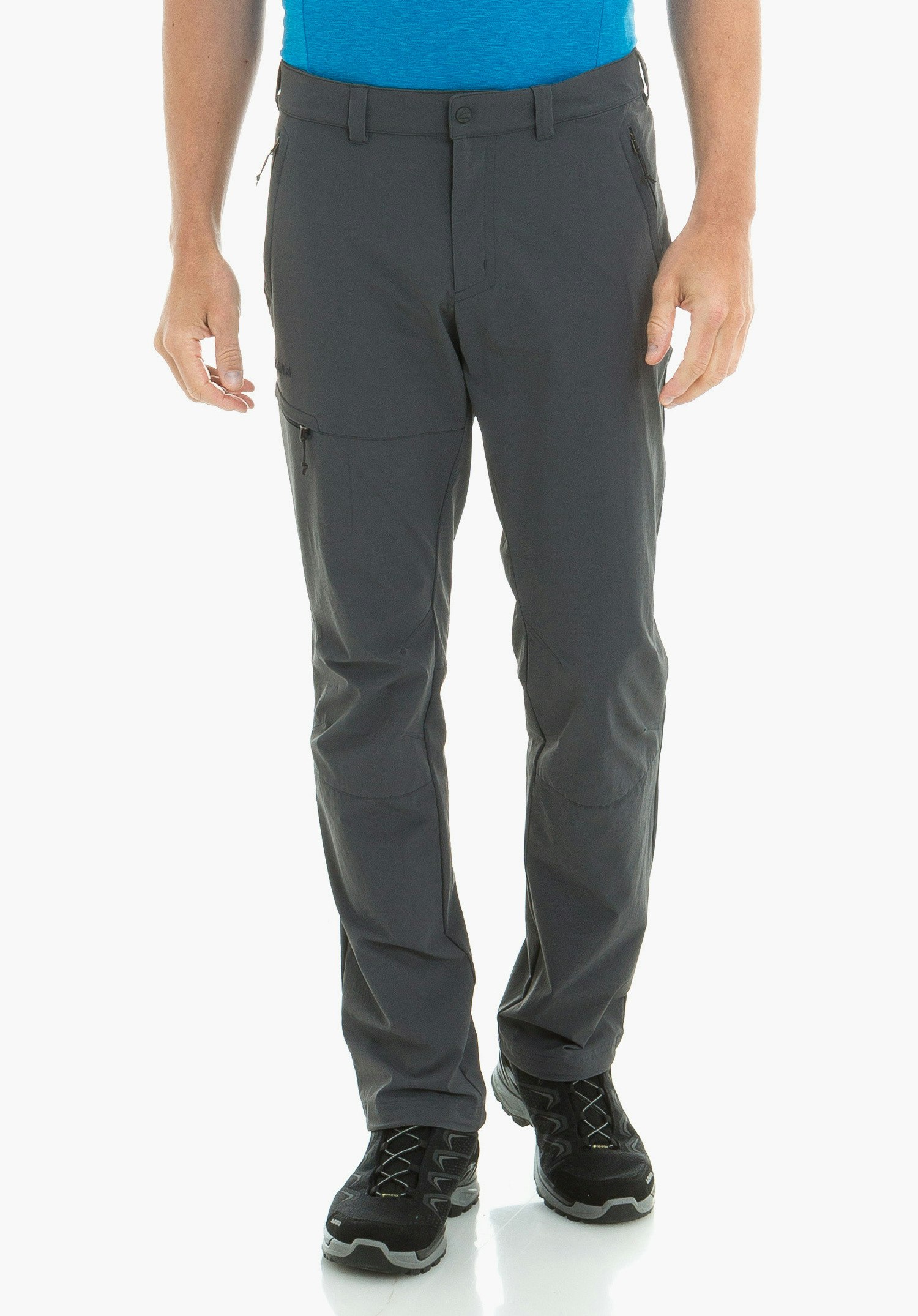 Pants Koper1 Pantalon porté par un homme debout de face; fond blanc, t-shirt bleu clair et chaussures de randonnée noires visibles.