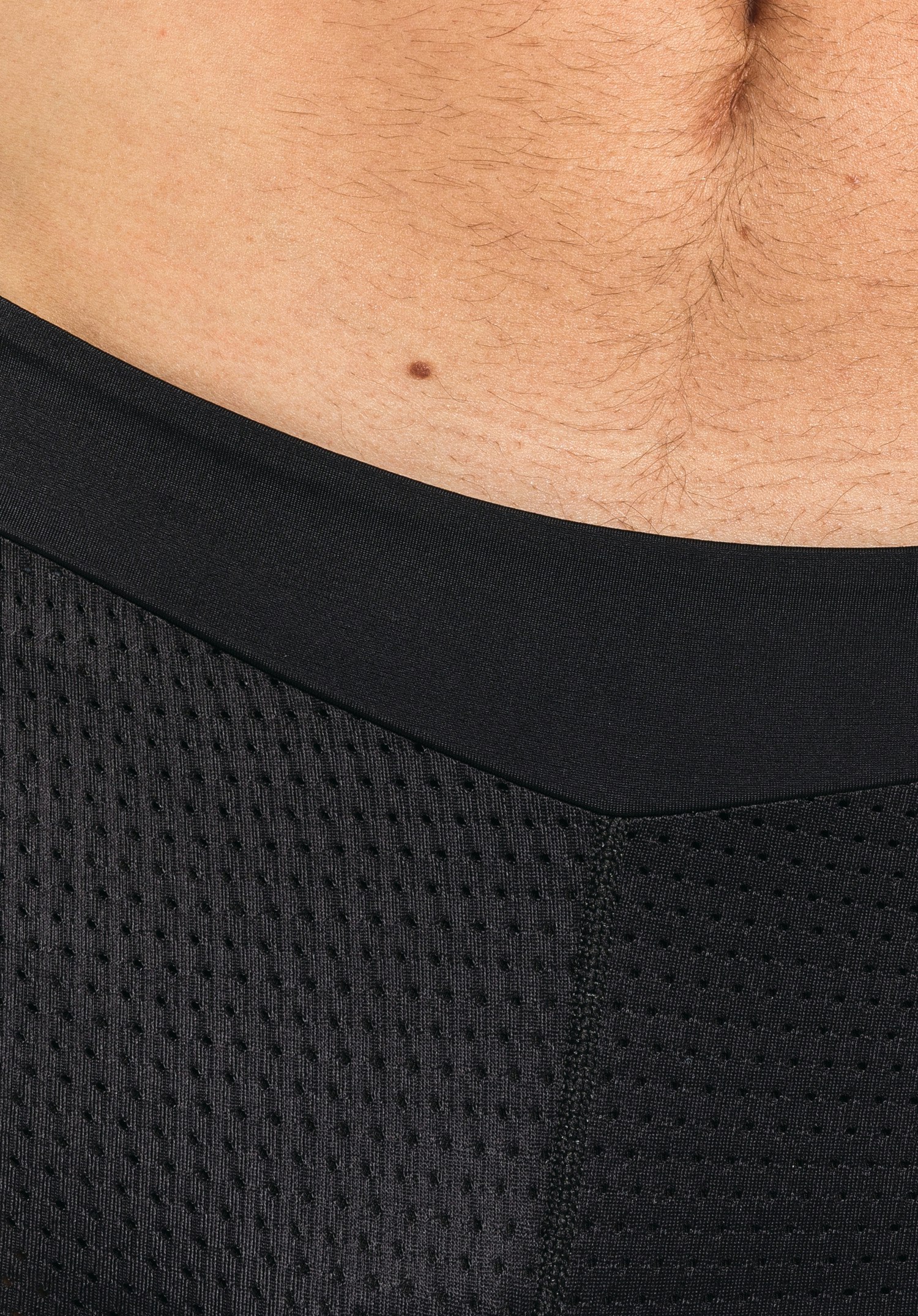 Skin Pants 8h M, la large ceinture confort et la structure en maille perforée du tissu noir, gros plan sur fond blanc.