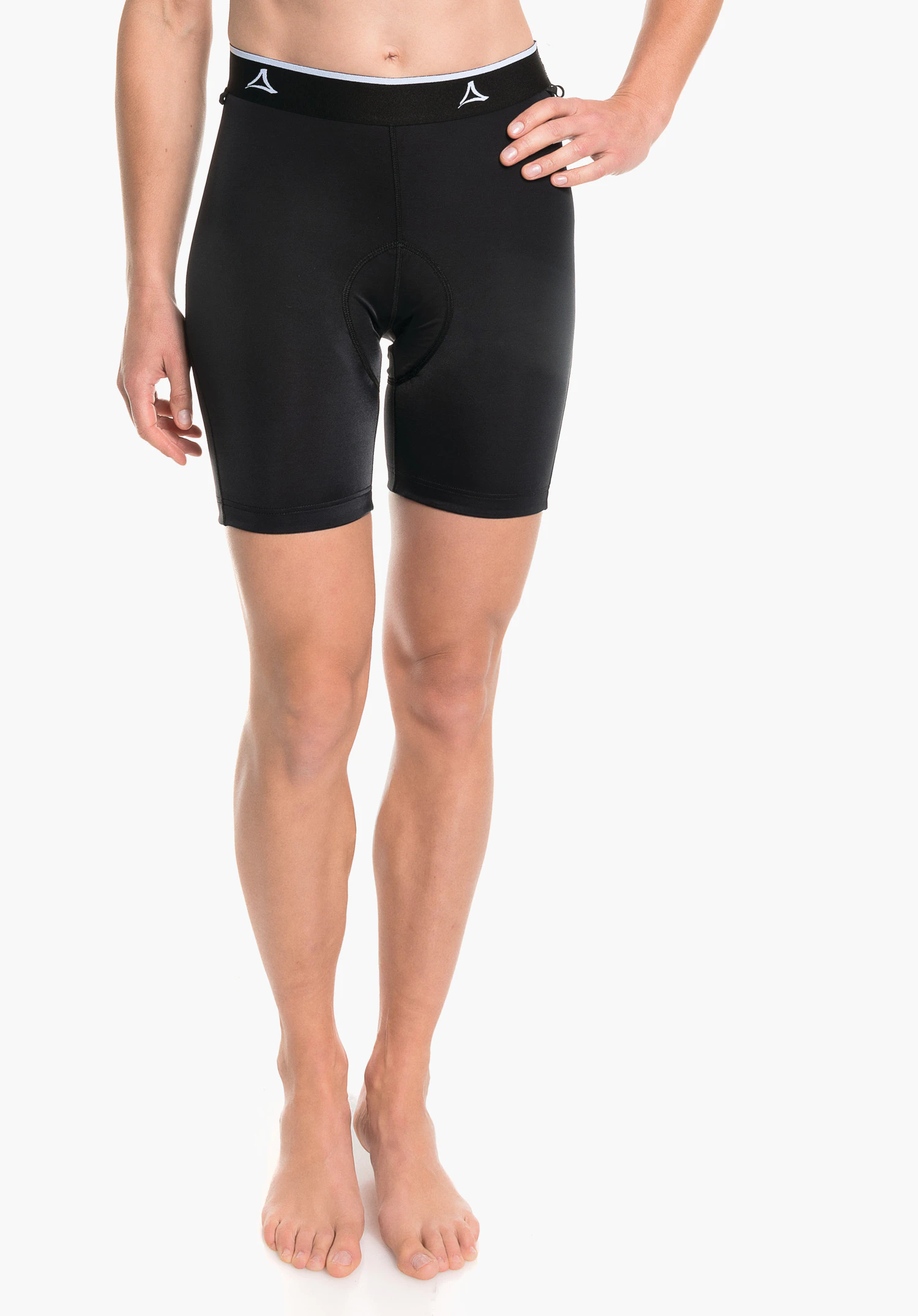 Skin Pants 2h L cuissard cycliste noir longueur genou avec logo Schöffel à la taille; modèle debout de face, une main sur la hanche; fond blanc, pieds nus.