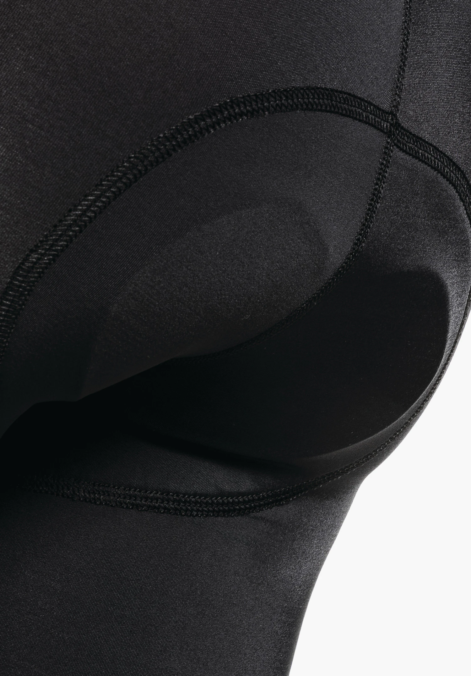 Skin Pants 2h L montre le contour du rembourrage d'assise intégré dans le tissu noir lisse. Gros plan sur fond blanc.
