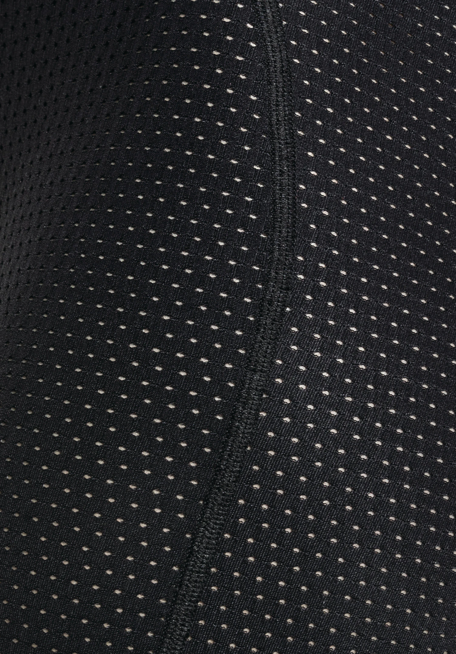 Skin Pants 8h L détail de la structure en tissu noir perforé assurant une grande respirabilité. Gros plan sur fond blanc/neutre.