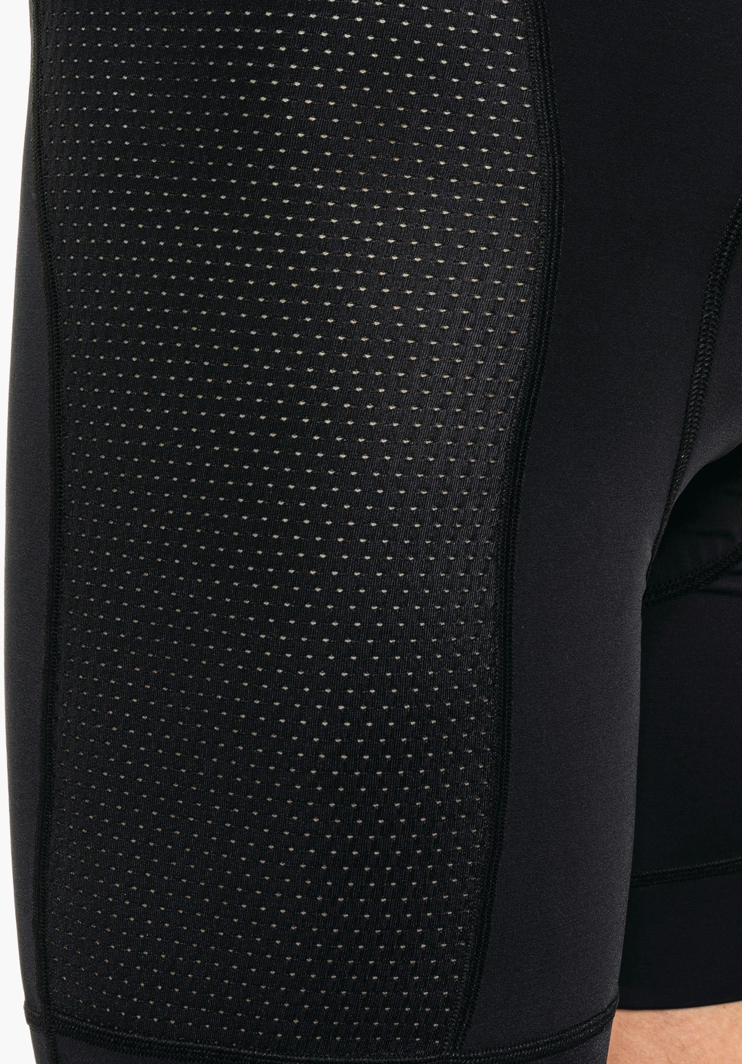 Skin Pants 4h M zeigt die atmungsaktive, perforierte Gewebestruktur an der Seite des Oberschenkels in Schwarz. Detailaufnahme vor weißem Hintergrund.