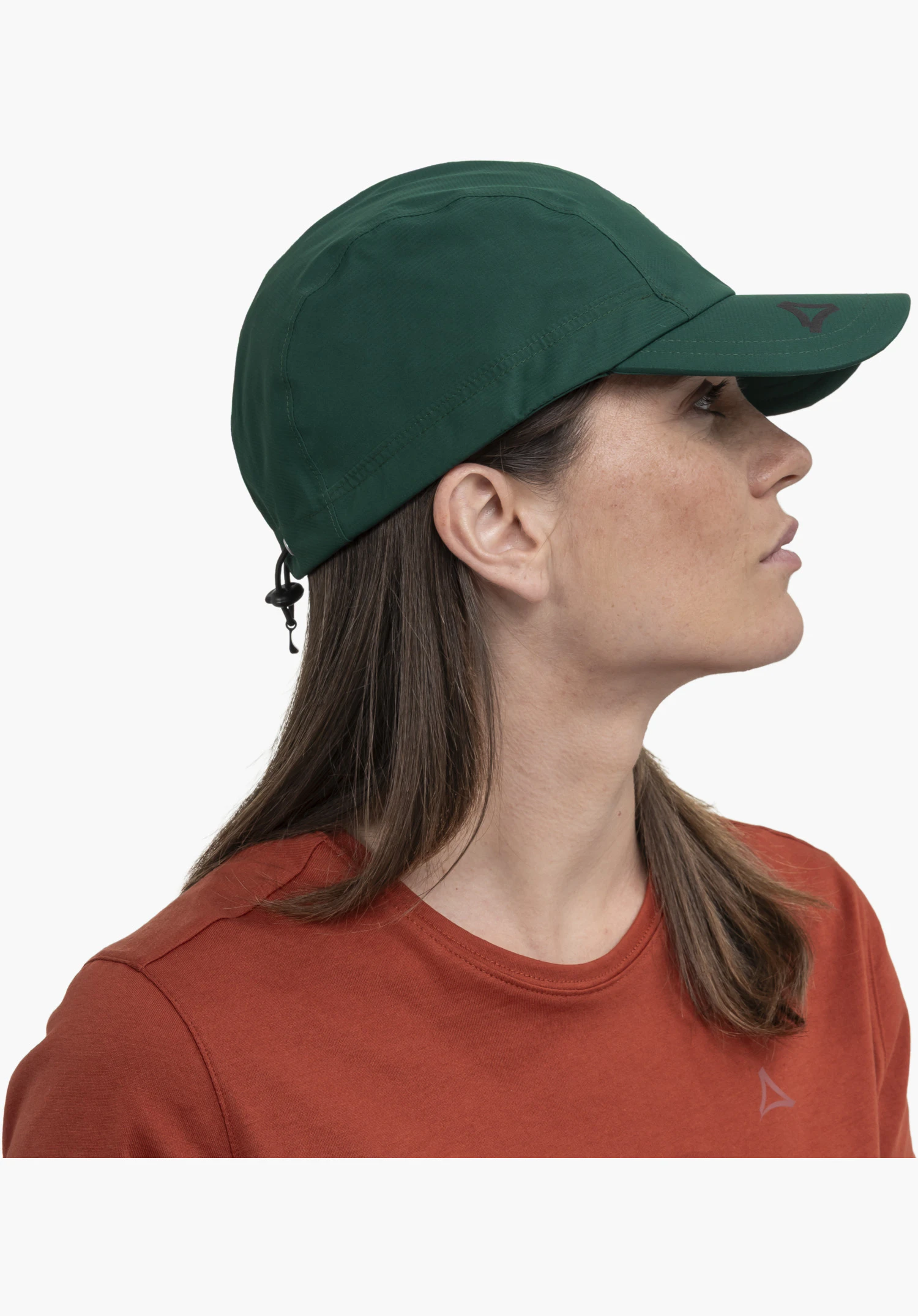 Rain Cap3, focus op de gladde groene stofstructuur, het donkere Schöffel-logo op de klep en het verstelbare trekkoord aan de achterkant, close-up tegen een witte/neutrale achtergrond.