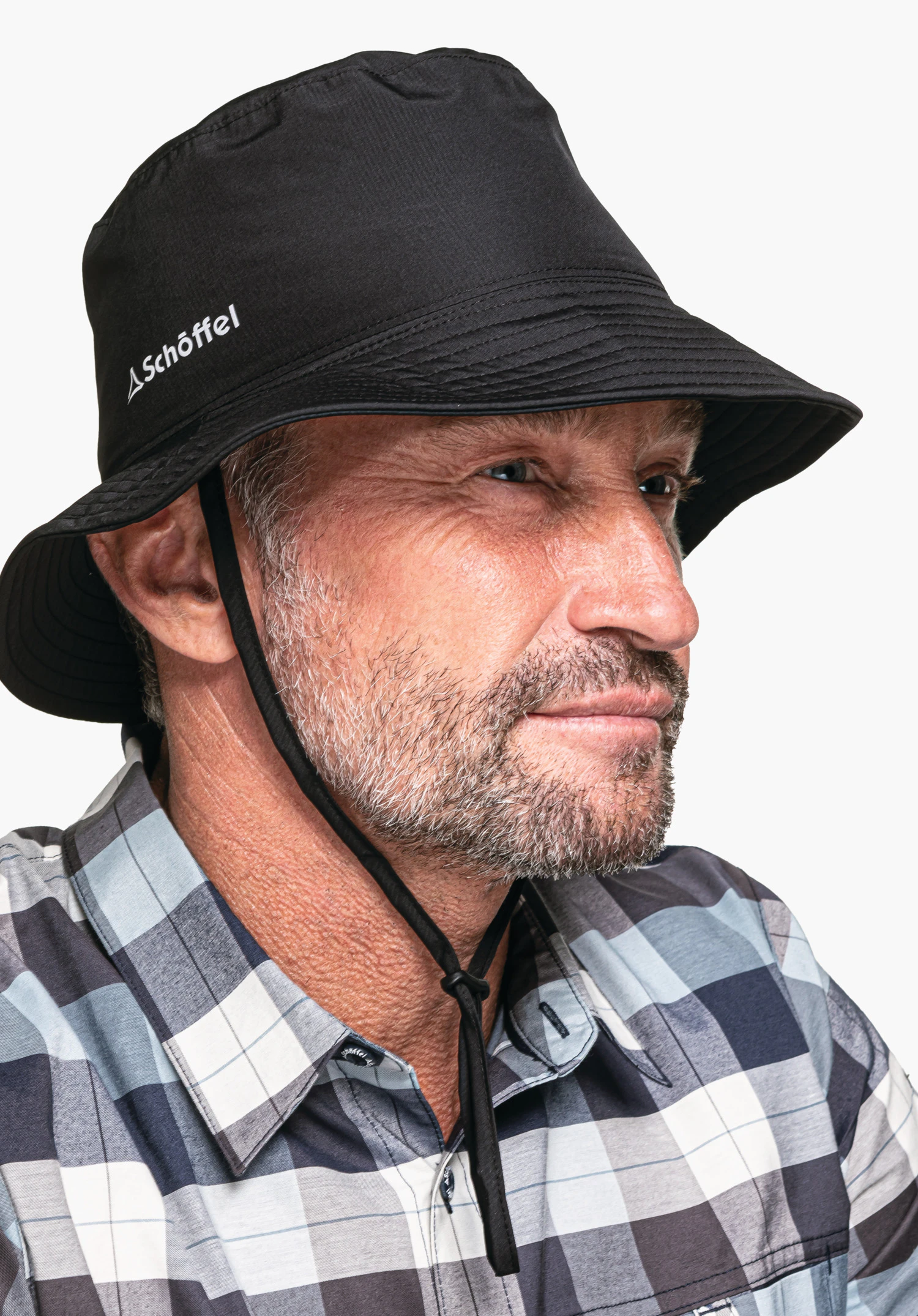 Rain Hat4, Fokus auf das weiße Schöffel-Logo auf dem schwarzen Stoff und das schmale, befestigte Kinnband, Nahaufnahme vor weißem Hintergrund.