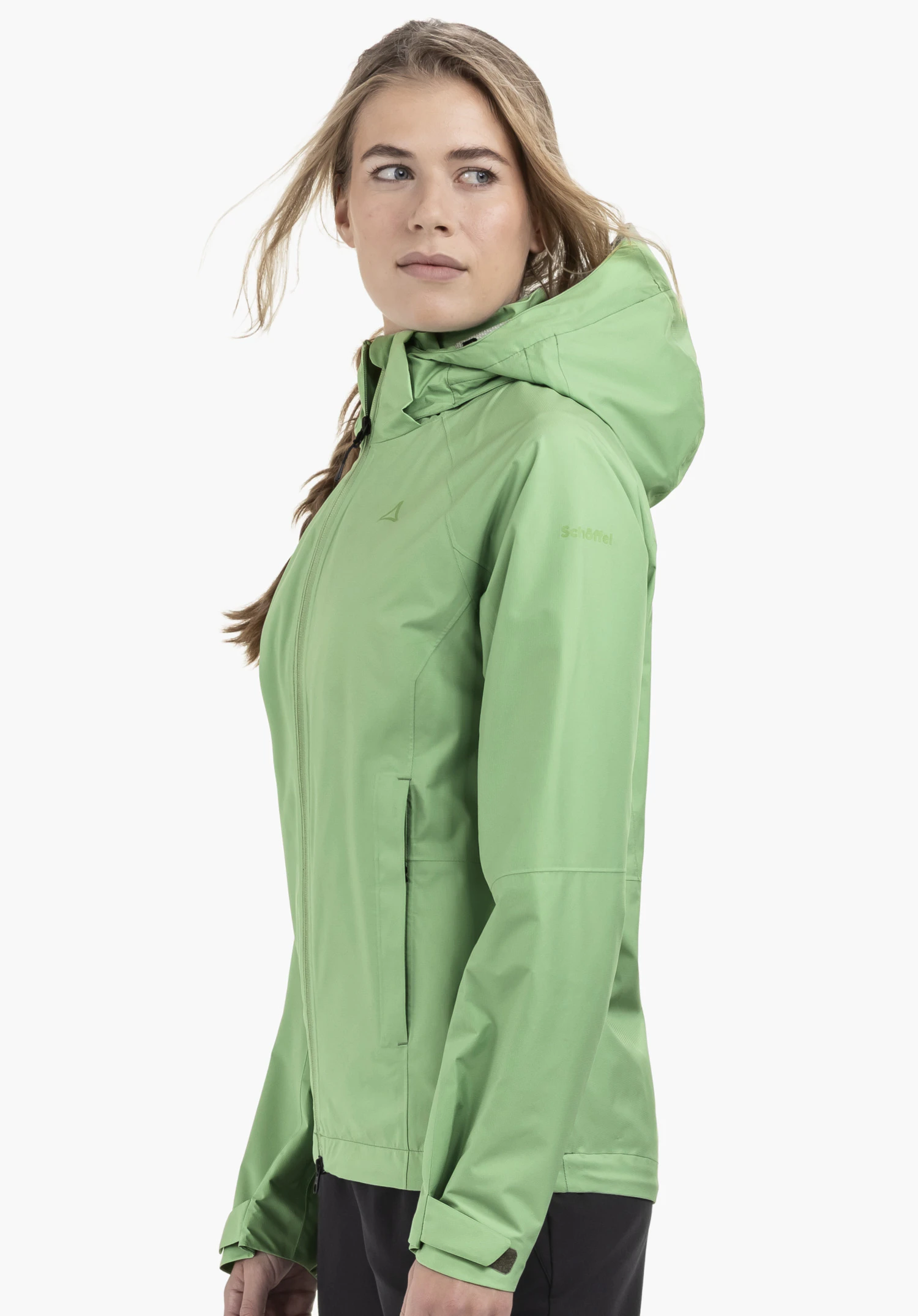 Jacket Easy XT L en vert. Un mannequin se tient de profil et porte la veste fermée avec le Schöffel-Logo visible sur la poitrine et la manche devant un fond neutre.