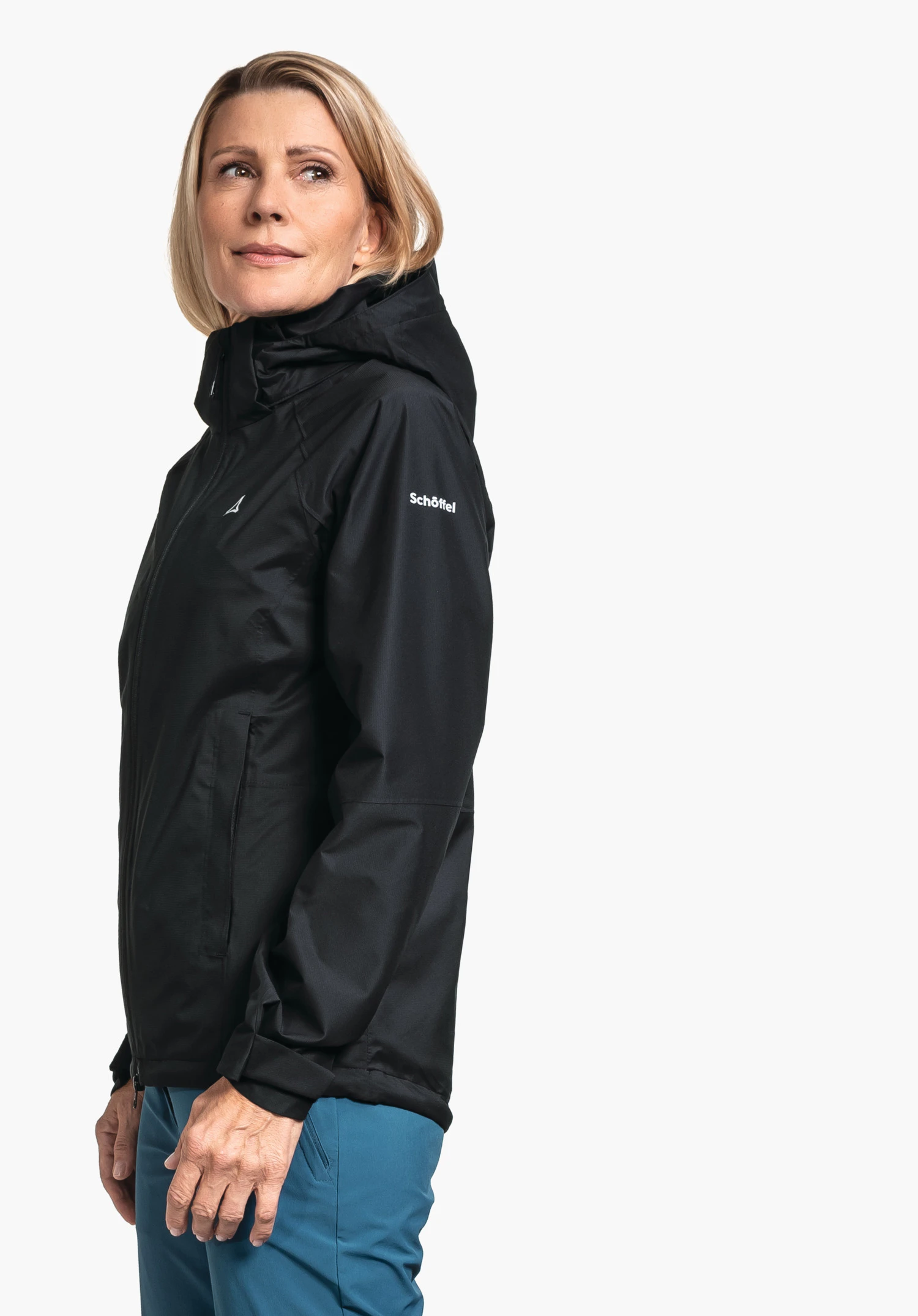 Jacket Easy XT L in black, worn by a model standing sideways. The white Schöffel-Logo is clearly visible on the chest and the left sleeve, photographed against a neutral background.