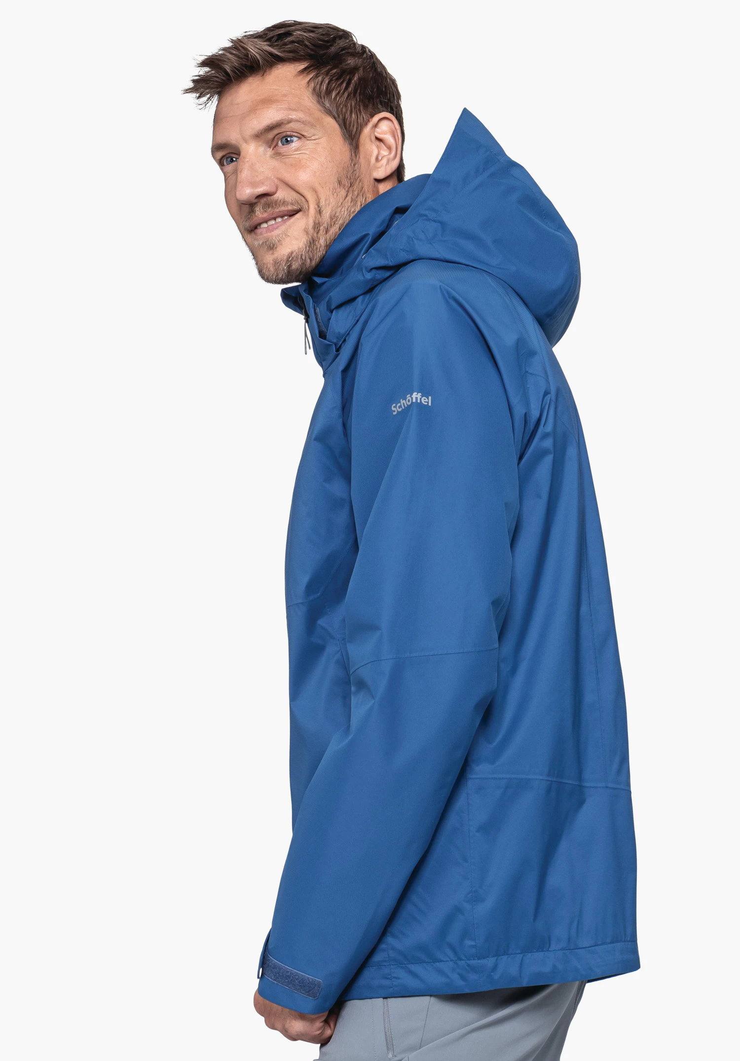Jacket Easy XT M worn by a model standing sideways. The blue jacket features the Schöffel logo on the sleeve against a neutral background.