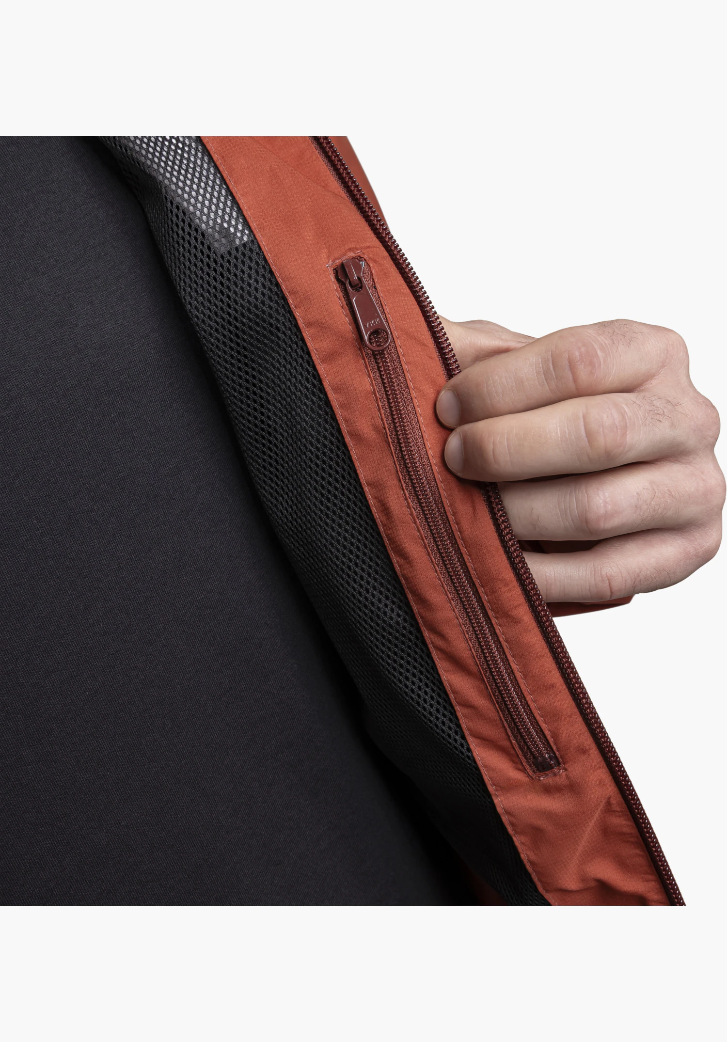 Jacket Easy XT M featuring a detail view of the red zip and black mesh lining, held slightly open by a hand, close-up against a white/neutral background.