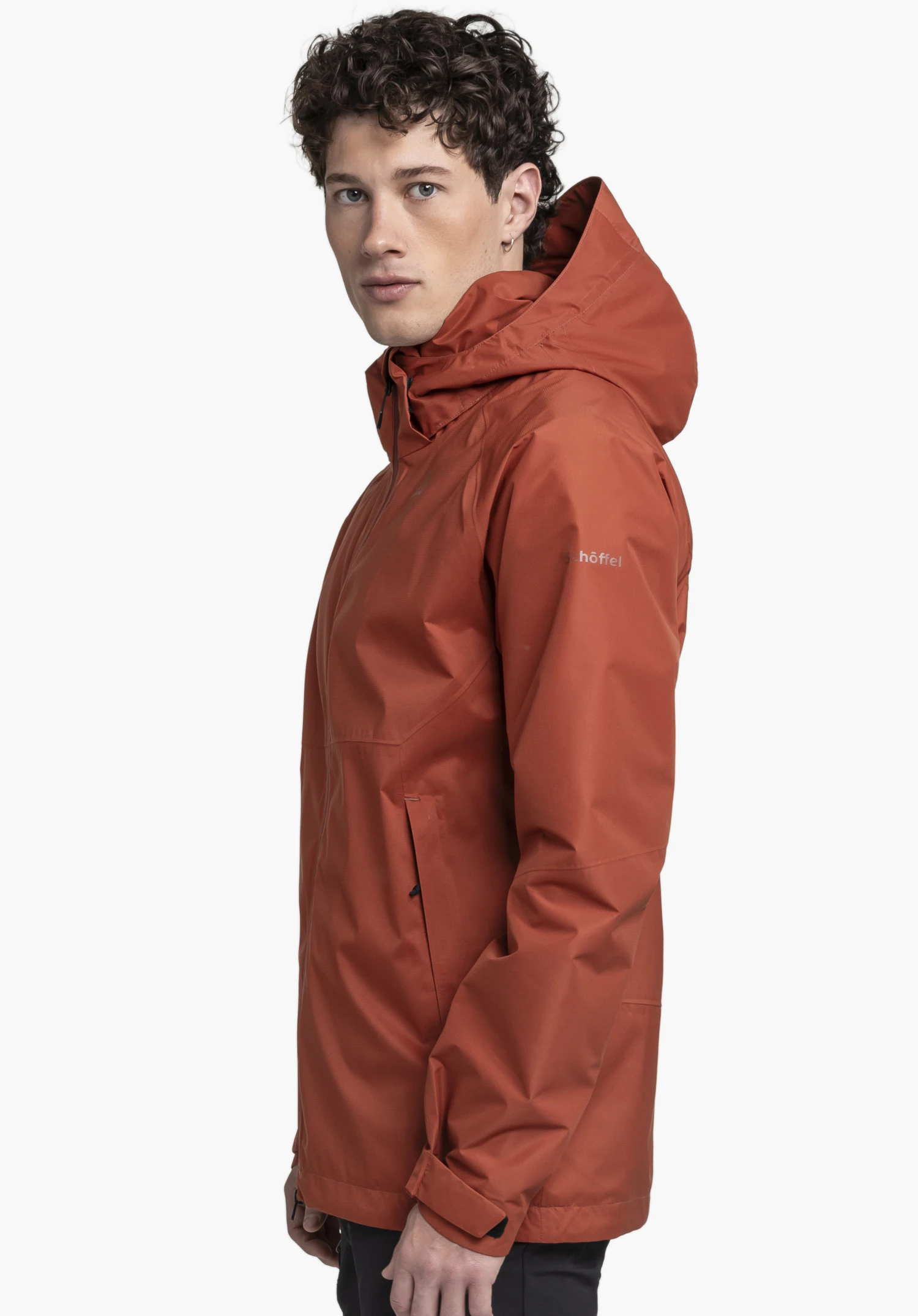 Jacket Easy XT M worn by a model standing sideways. The red jacket clearly displays the Schöffel-Logo on the left sleeve and is presented against a neutral background.
