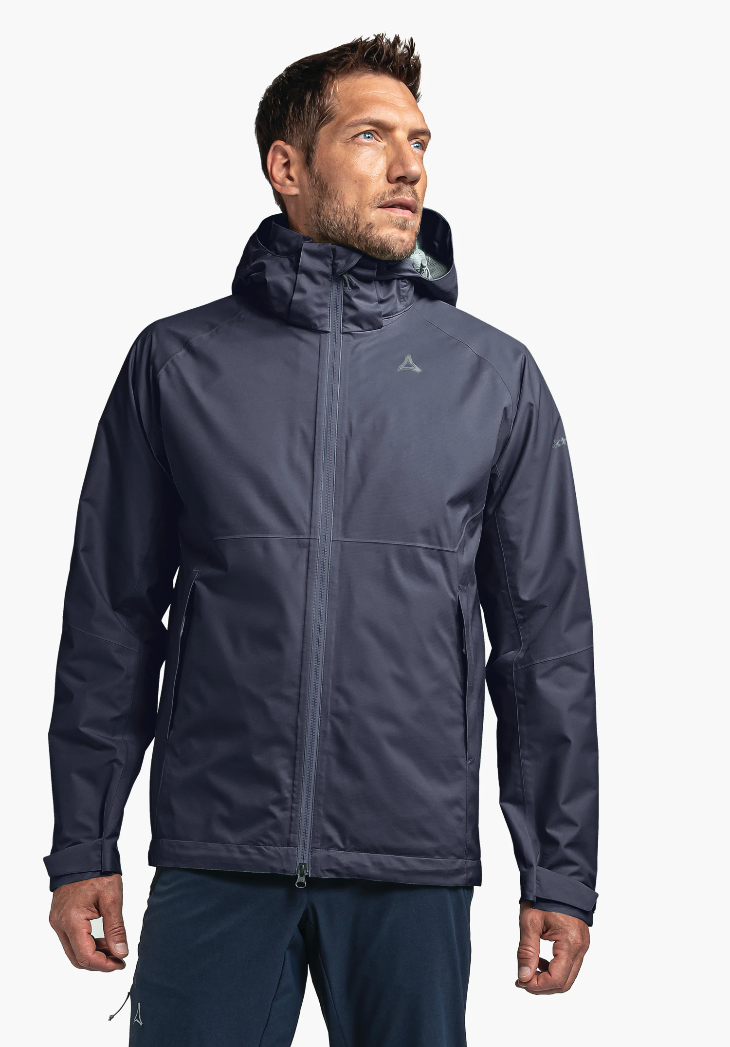 Jacket Easy XT M on a model standing frontally and looking to the side. The blue jacket features the Schöffel logo on the left chest and is presented against a neutral background.