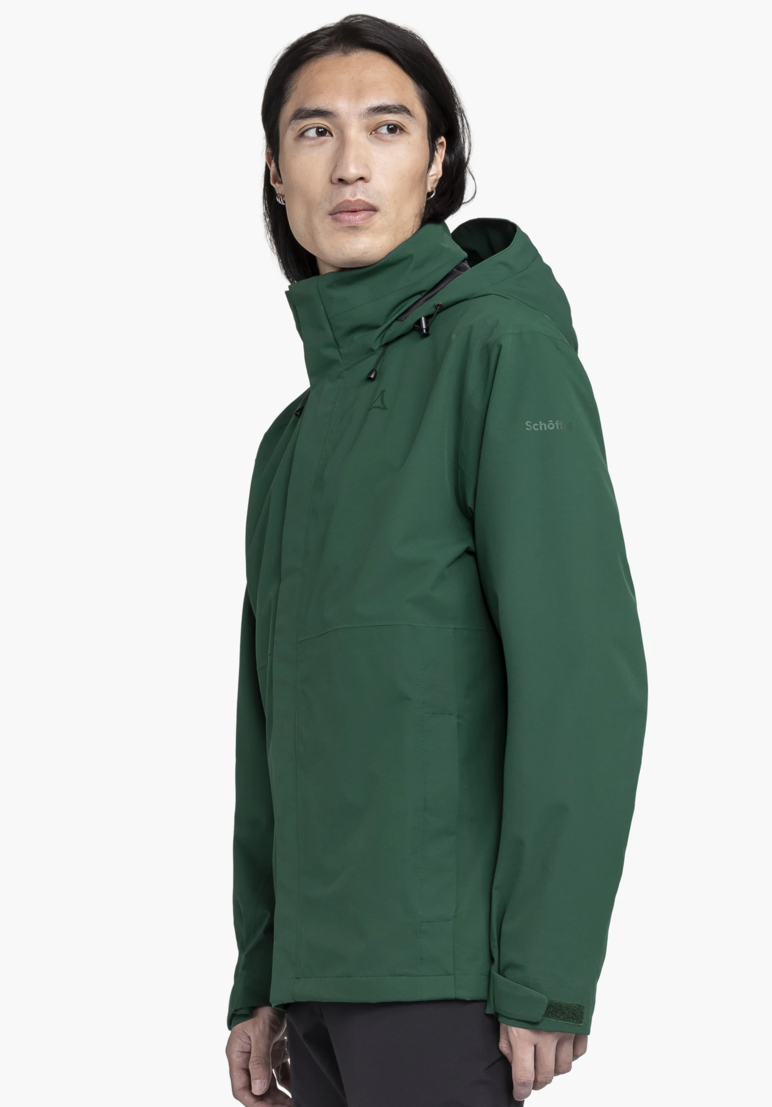 Jacket Gmund M in green. A model showcases the jacket in a side view against a neutral background. The shot highlights the fit and the subtly placed Schöffel logo on the upper arm.