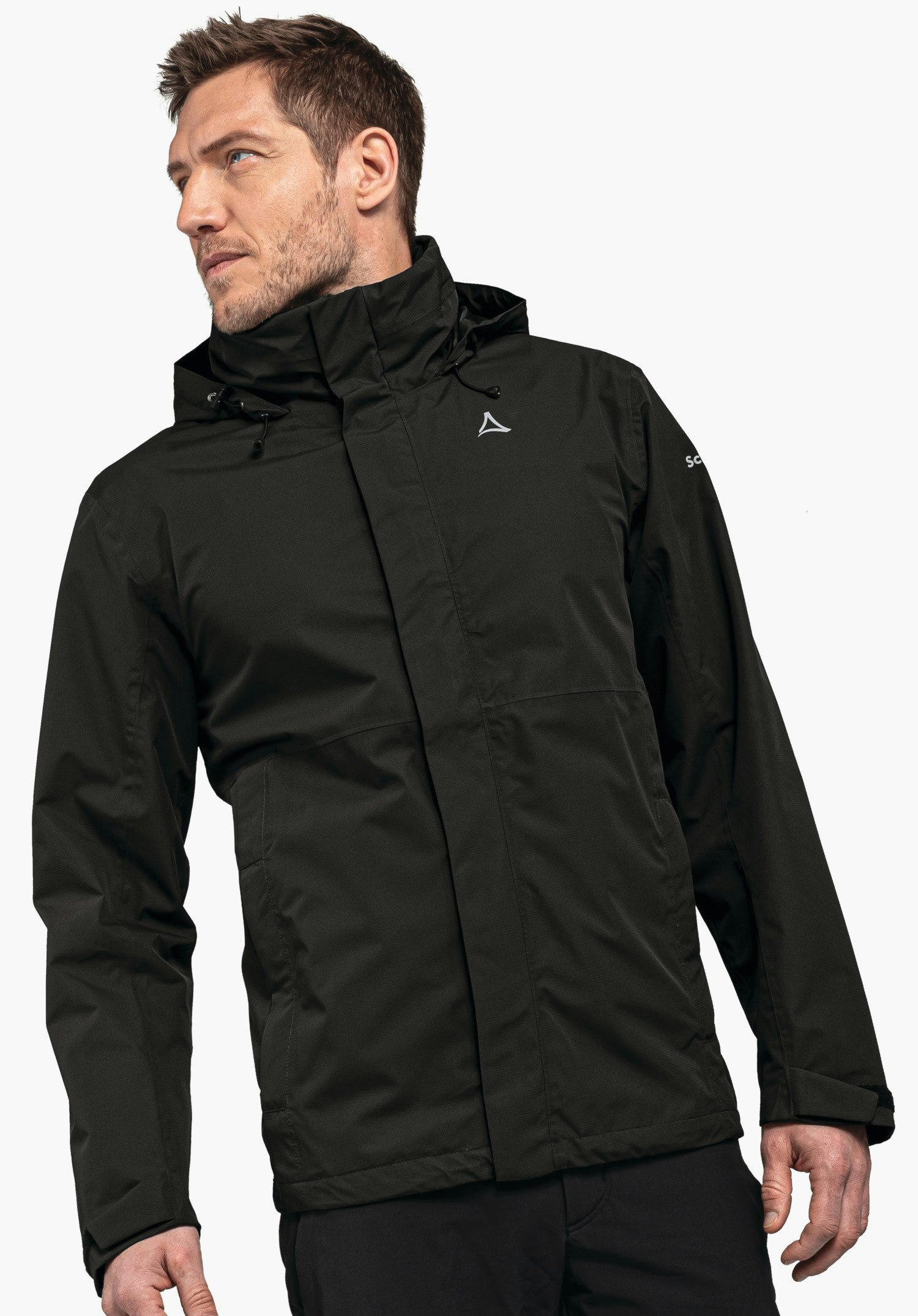 Jacket Gmund M Black rain jacket with white Schöffel logo, worn by a man looking slightly to the left; hood pulled up; plain light background. Text on sleeve: “SC”.