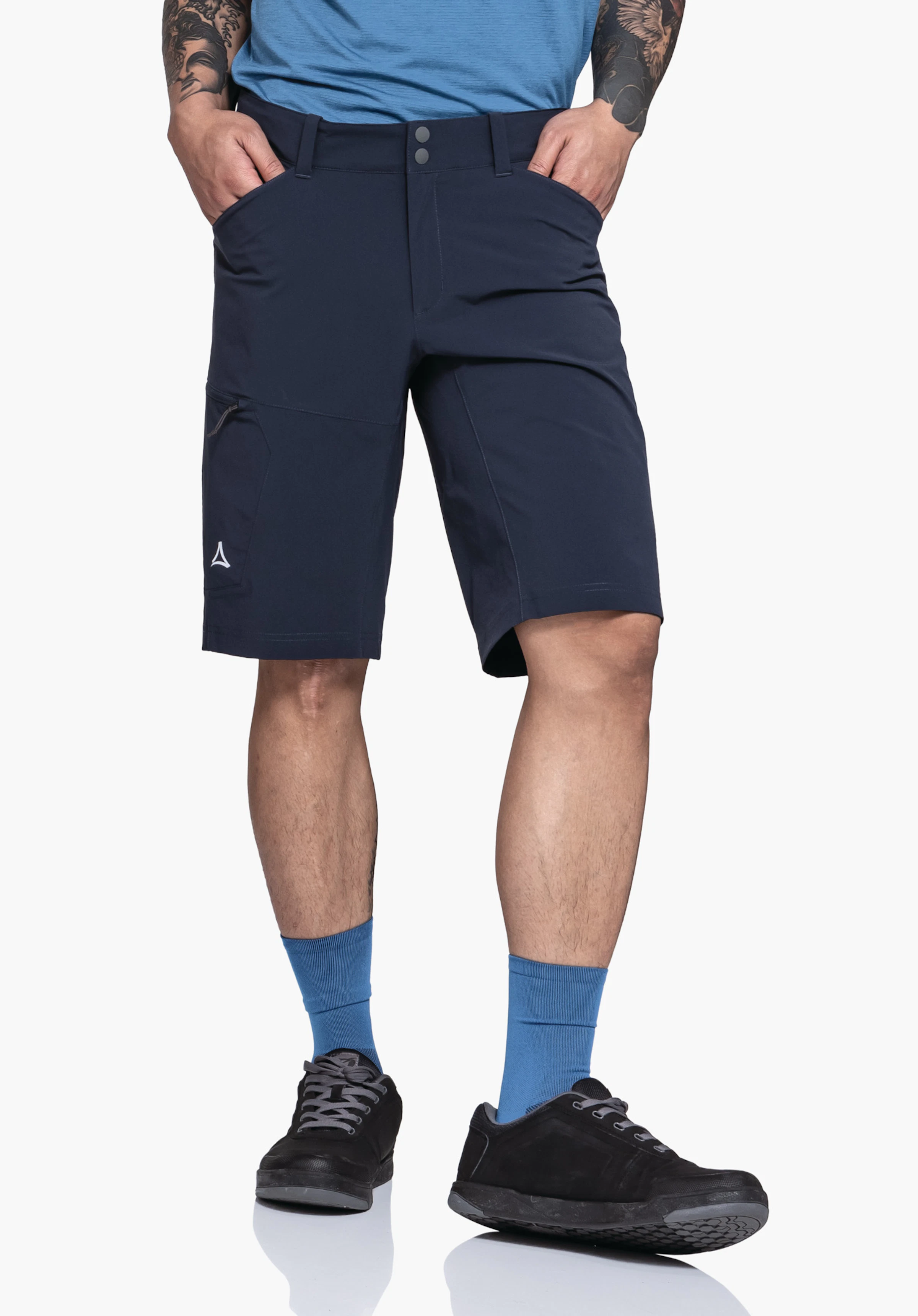 Shorts Danube M gedragen door een model dat frontaal staat met de handen in de zakken. De shorts in blauw tonen het Schöffel-logo op het rechterbeen tegen een neutrale achtergrond.