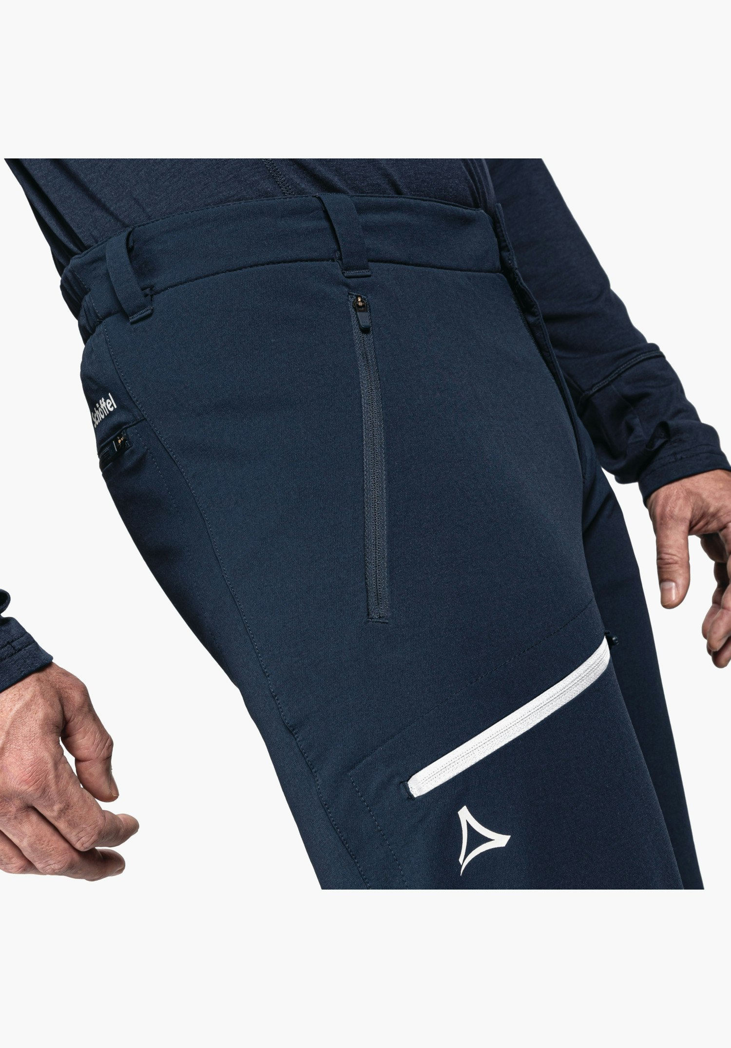 Pants Folkstone Warm M shows the thigh pocket with white zip and the Schöffel logo on the blue fabric, close-up against a neutral background.